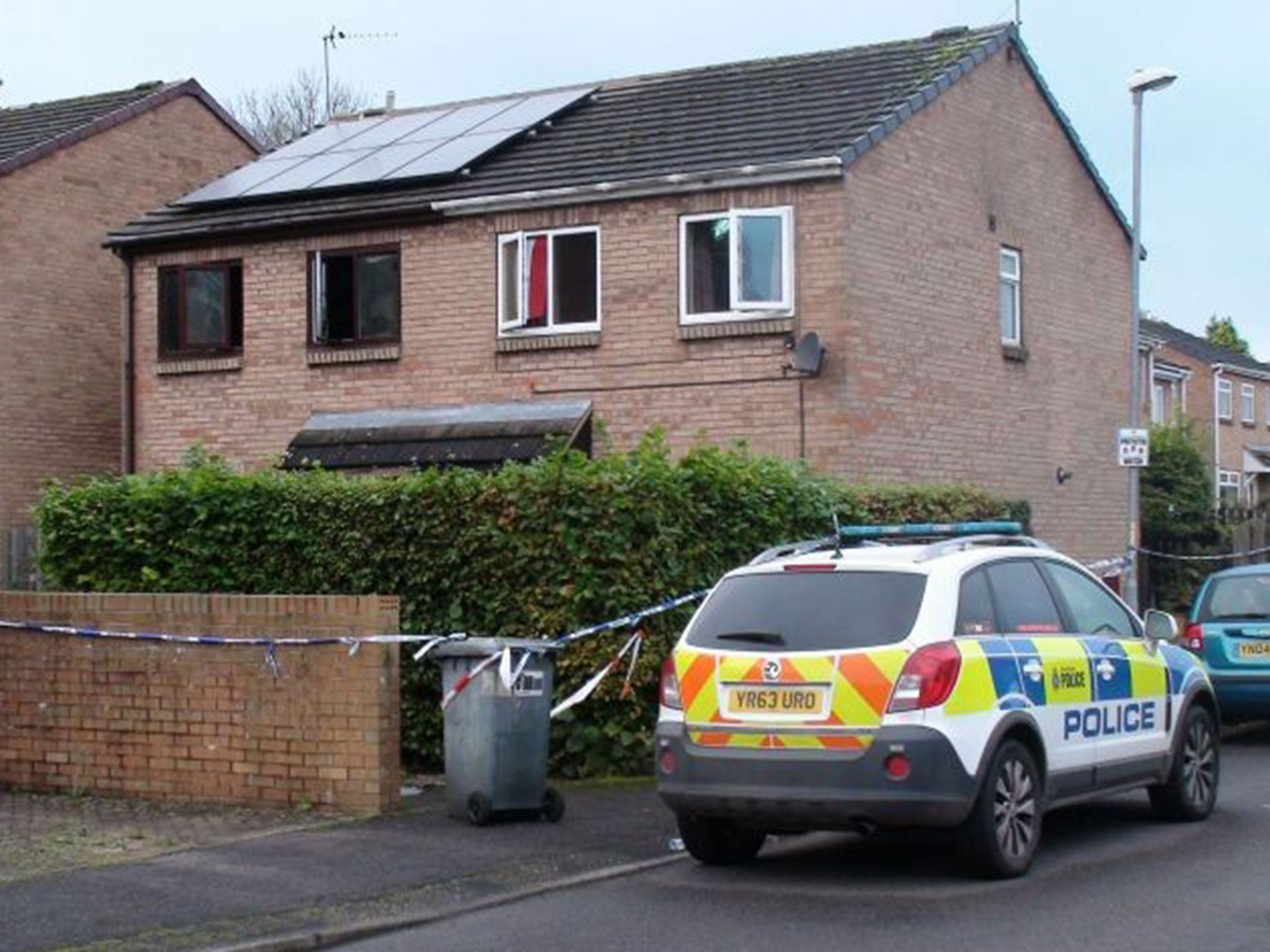 Police at the house where a fire killed a father and his two sons