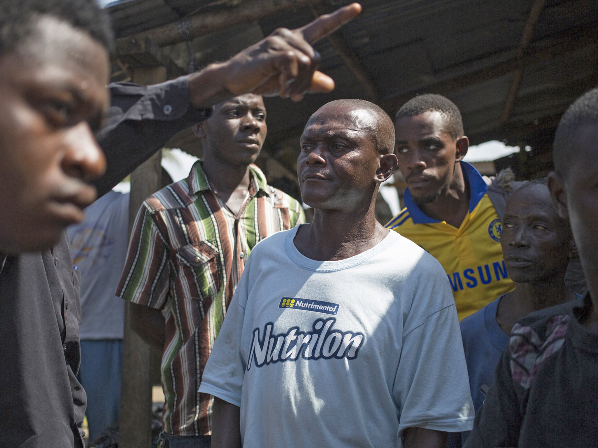 Residents help guide Bobby Pomney to the home of an Ebola victim in Monrovia so he can try to identify others who have come into contact with the virus