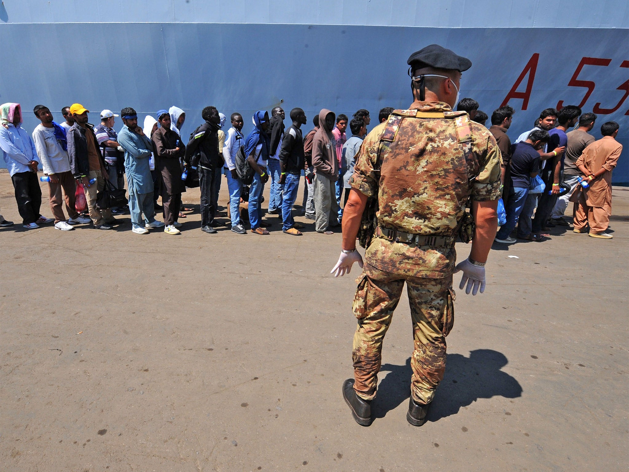 Illegal immigrants disembark from an Italian military ship in July (Getty)