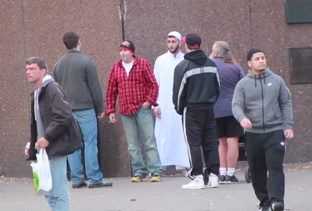 Devin (second left) arguing with a man (middle) who defends Zack (in white) before the man in cap punches him