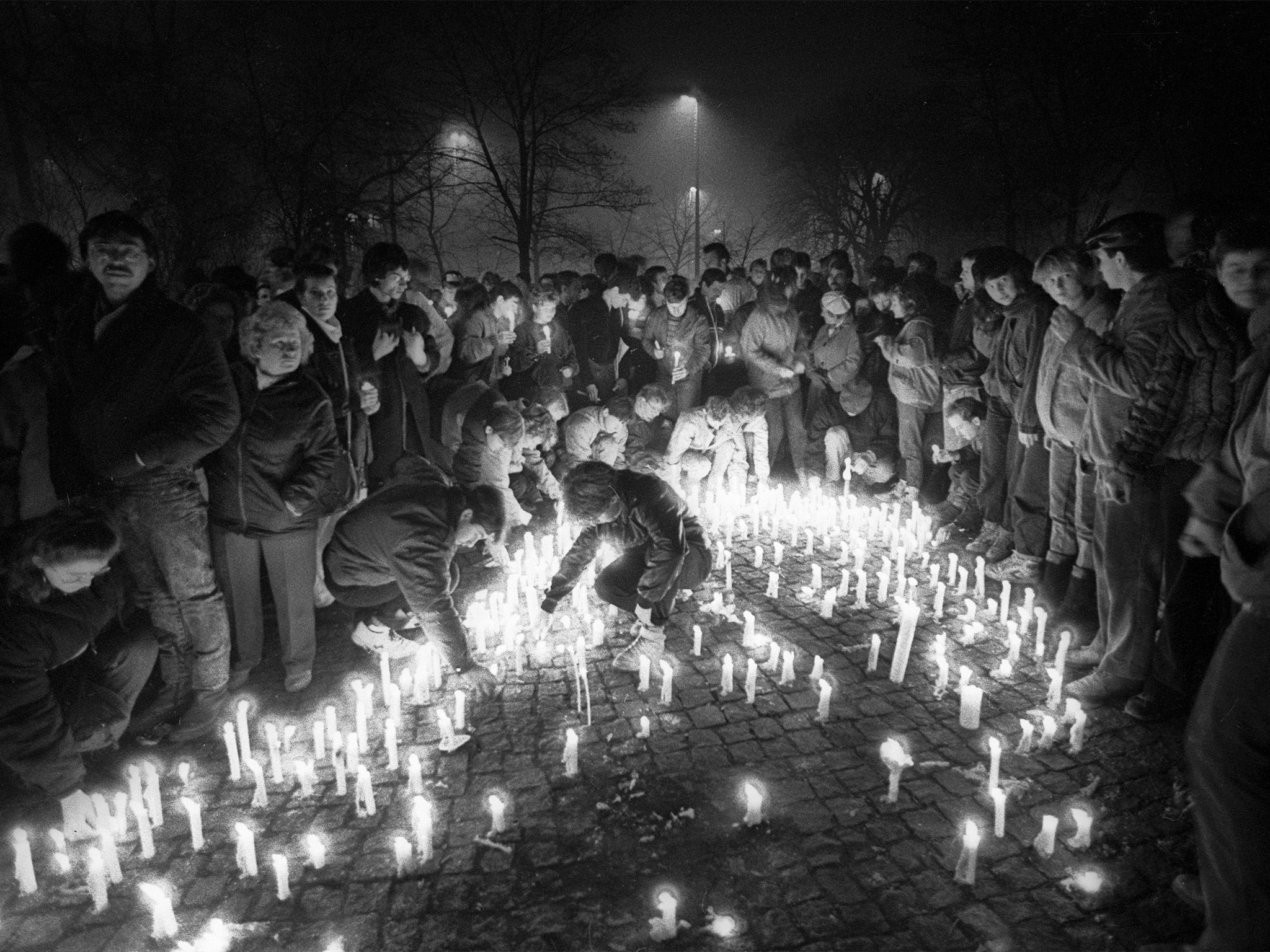 East Germans at a candlelit protest outside the dreaded secret police Stasi HQ, in November 1989