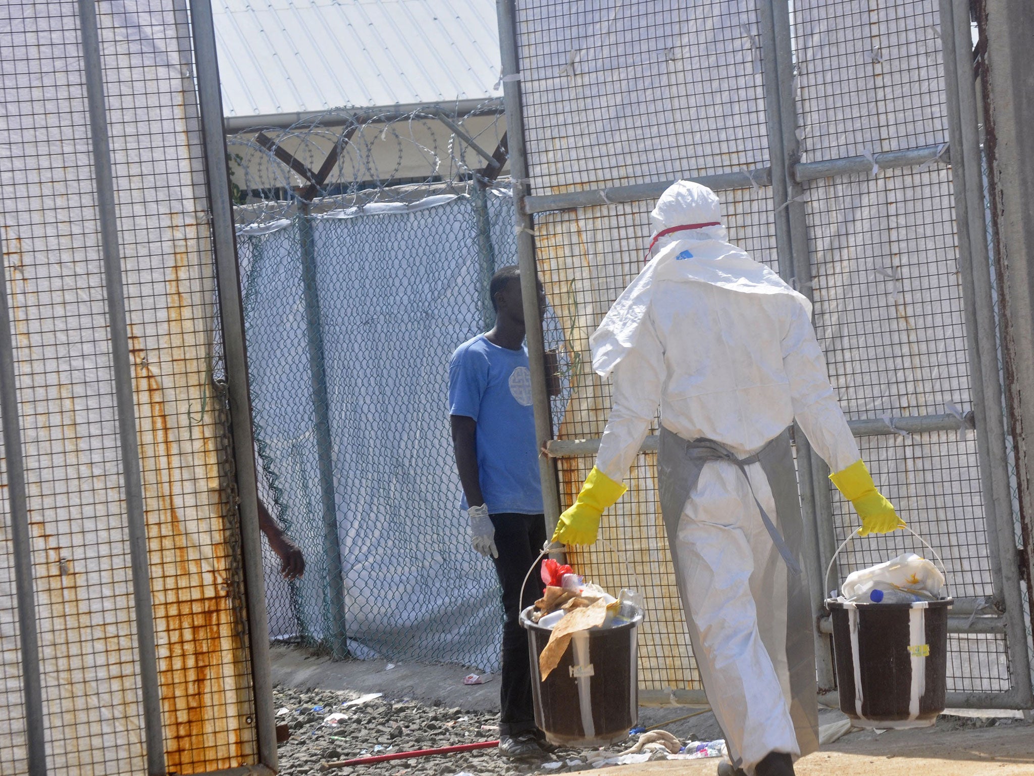 An Ebola health worker removes rubbish from the Island Clinic Treatment center in Monrovia, Liberia, on Wednesday, October 29