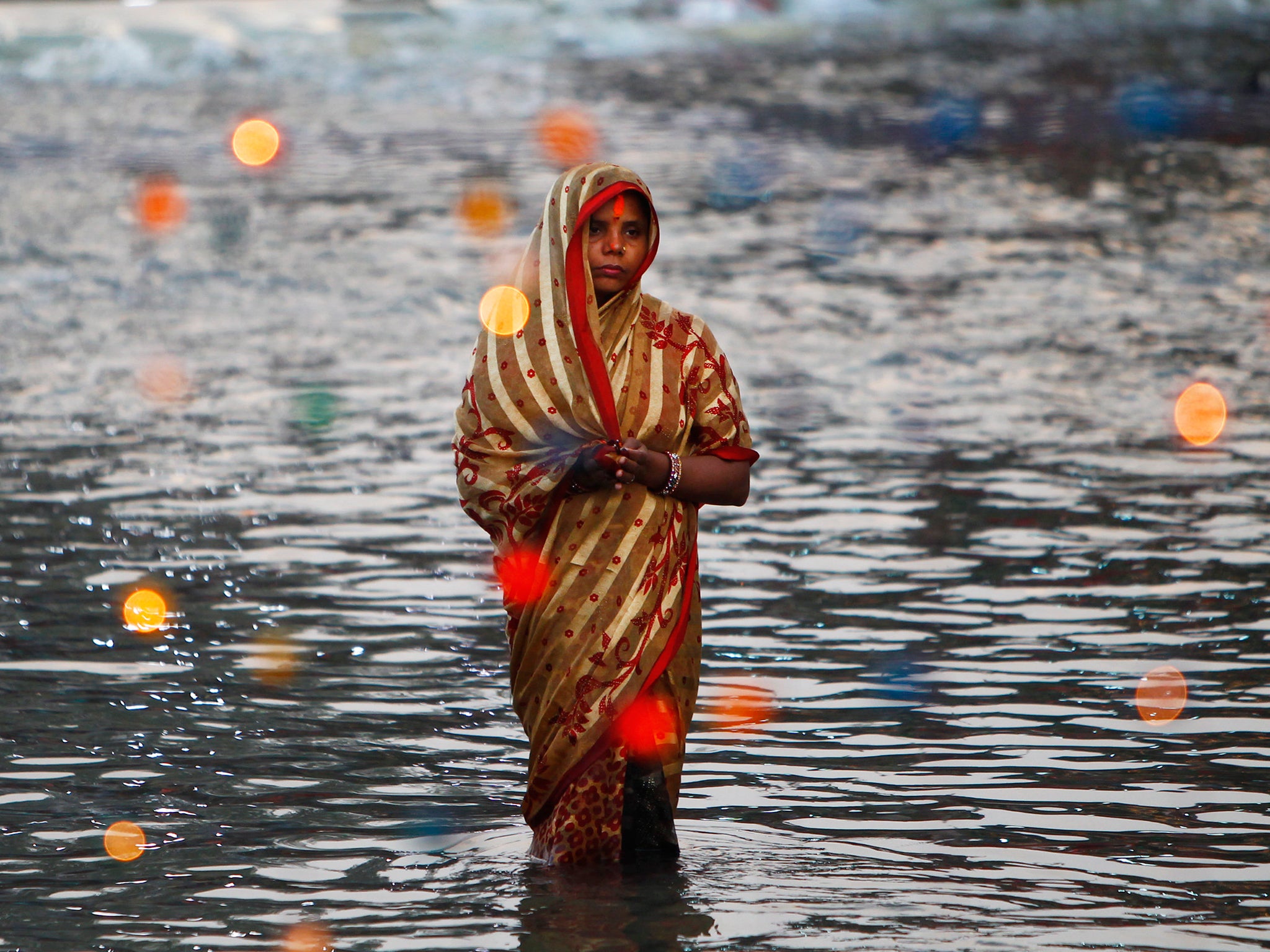 A Nepalese woman offers prayers during rituals marking Chhath festival at the Bagmati River in Katmandu, Nepal