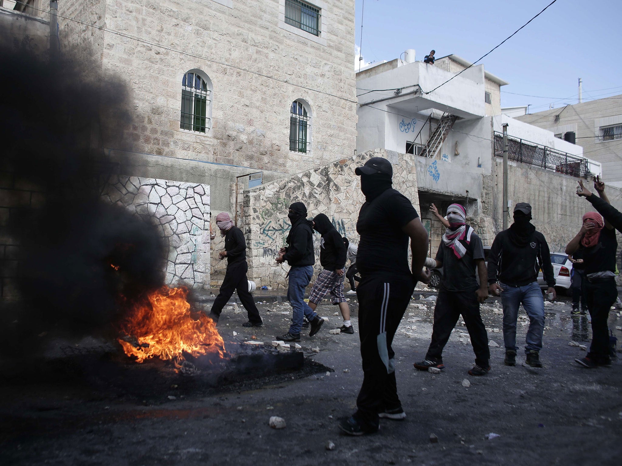 Masked Palestinian youths clash with Israeli security forces in the east Jerusalem neighbourhood of Abu Tor on Thursday