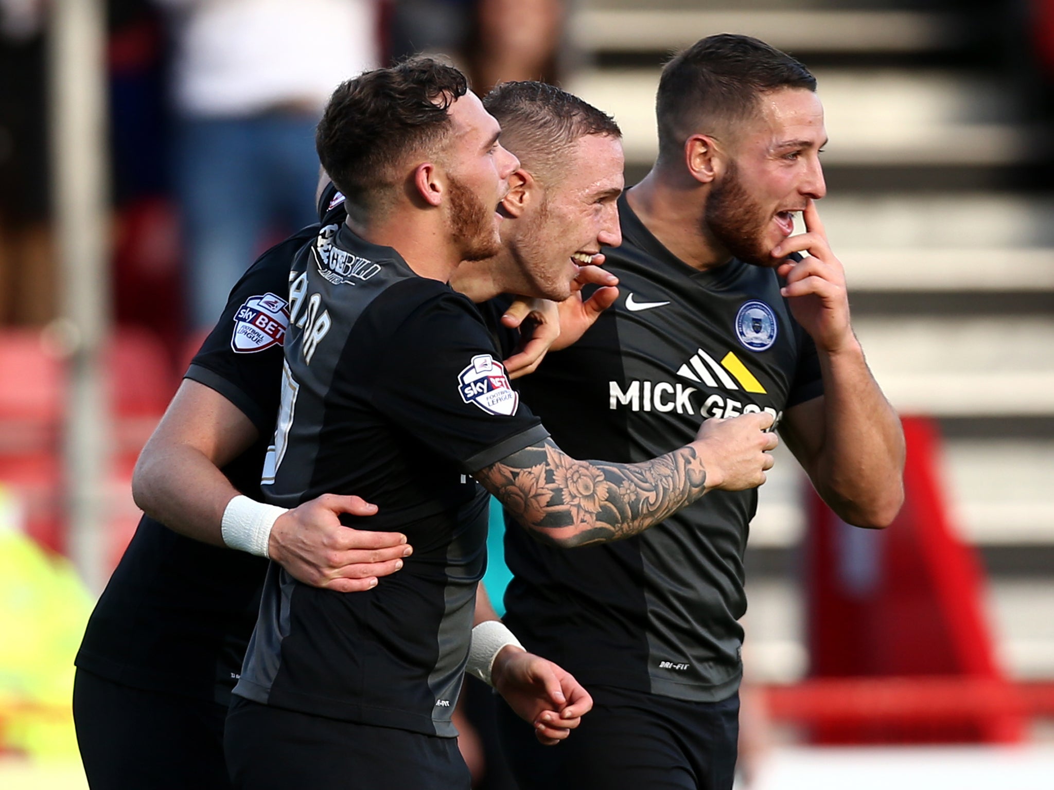 Peterborough players celebrate with Marcus Maddison (2nd L) of Peterborough after he scored