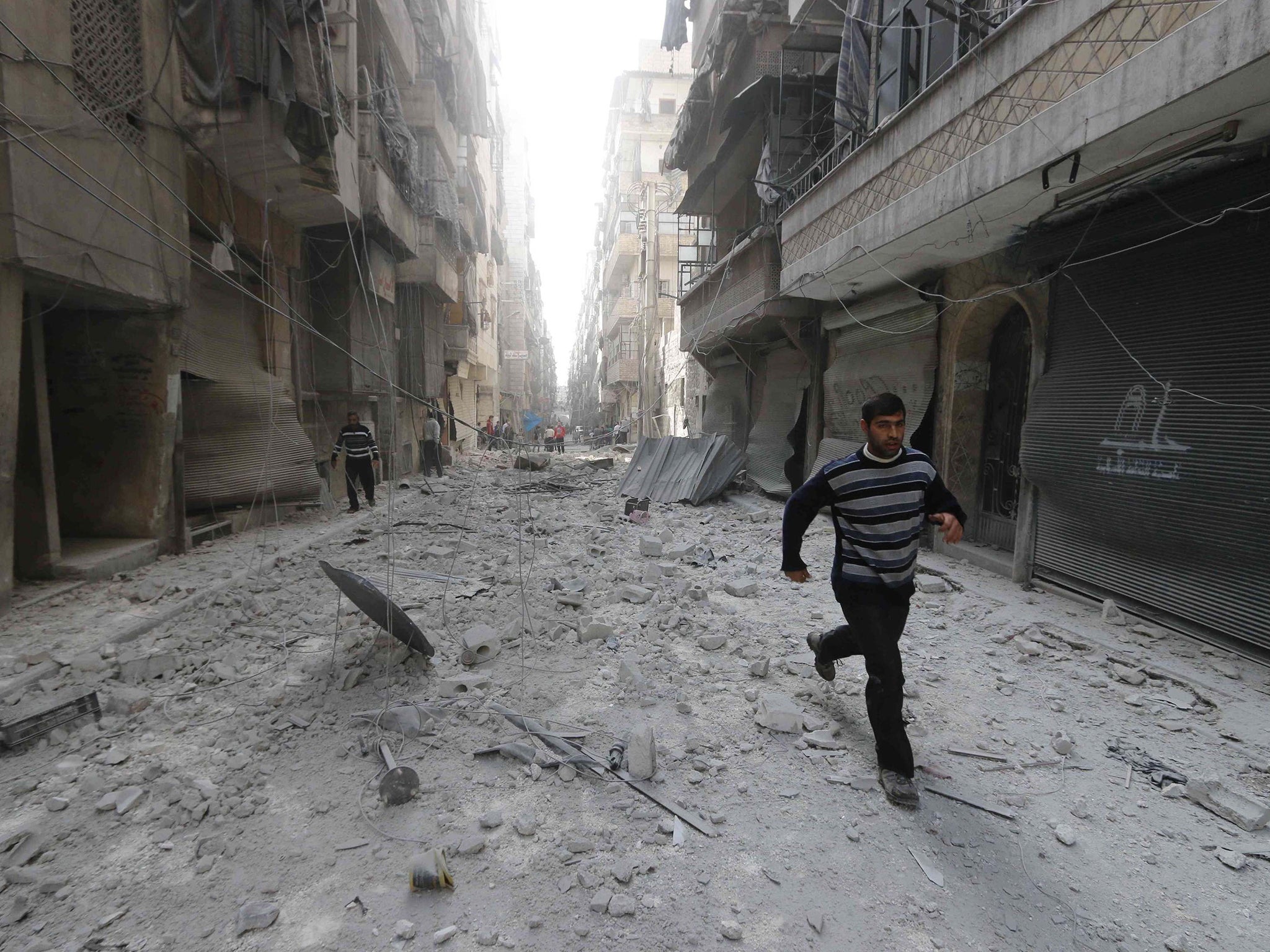 A man runs at a site hit by an airstrike in Aleppo