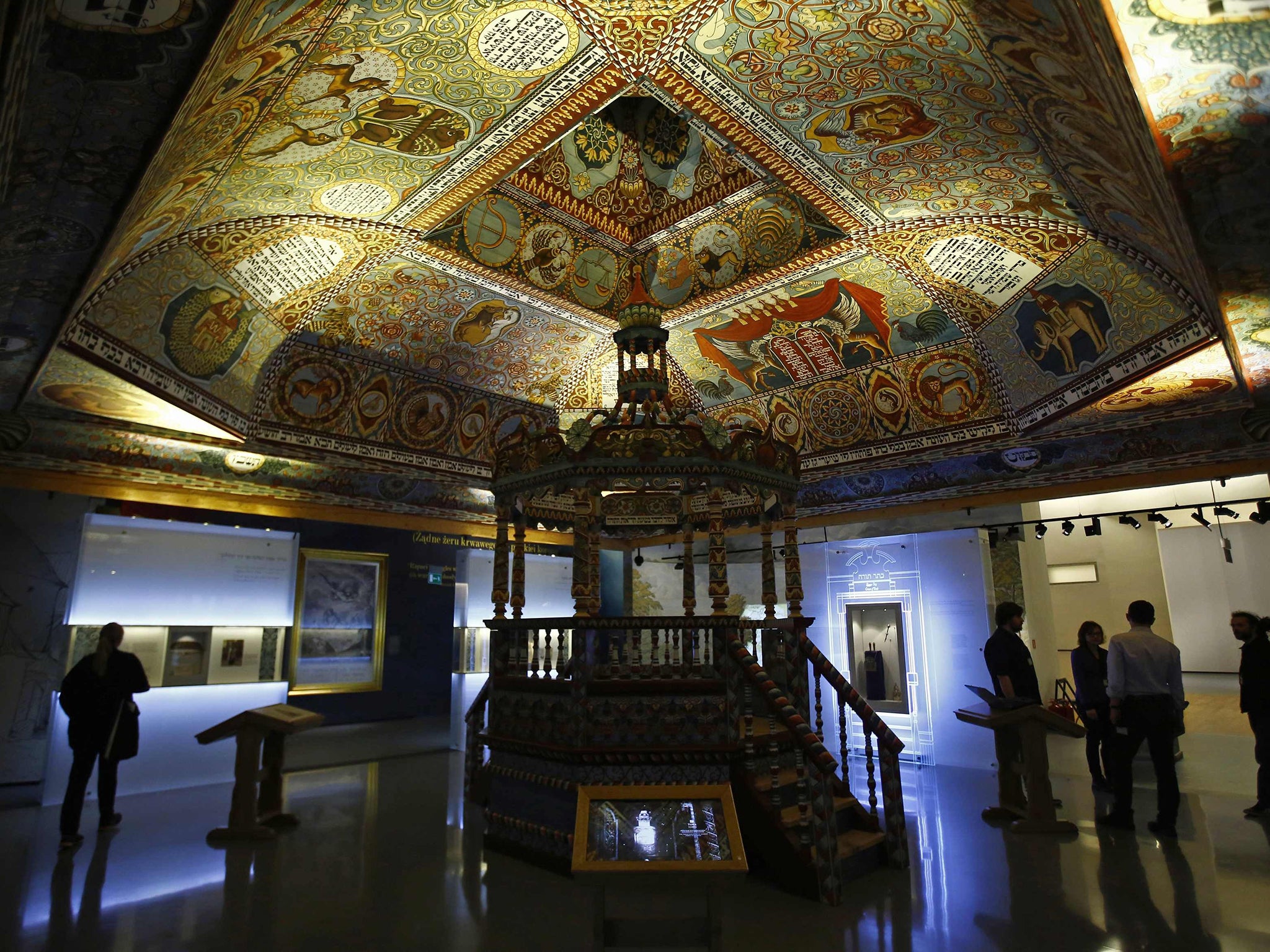 Visitors stand under the "Celestial Canopy", a reconstructed painted ceiling of a synagogue that once stood in Gwozdziec