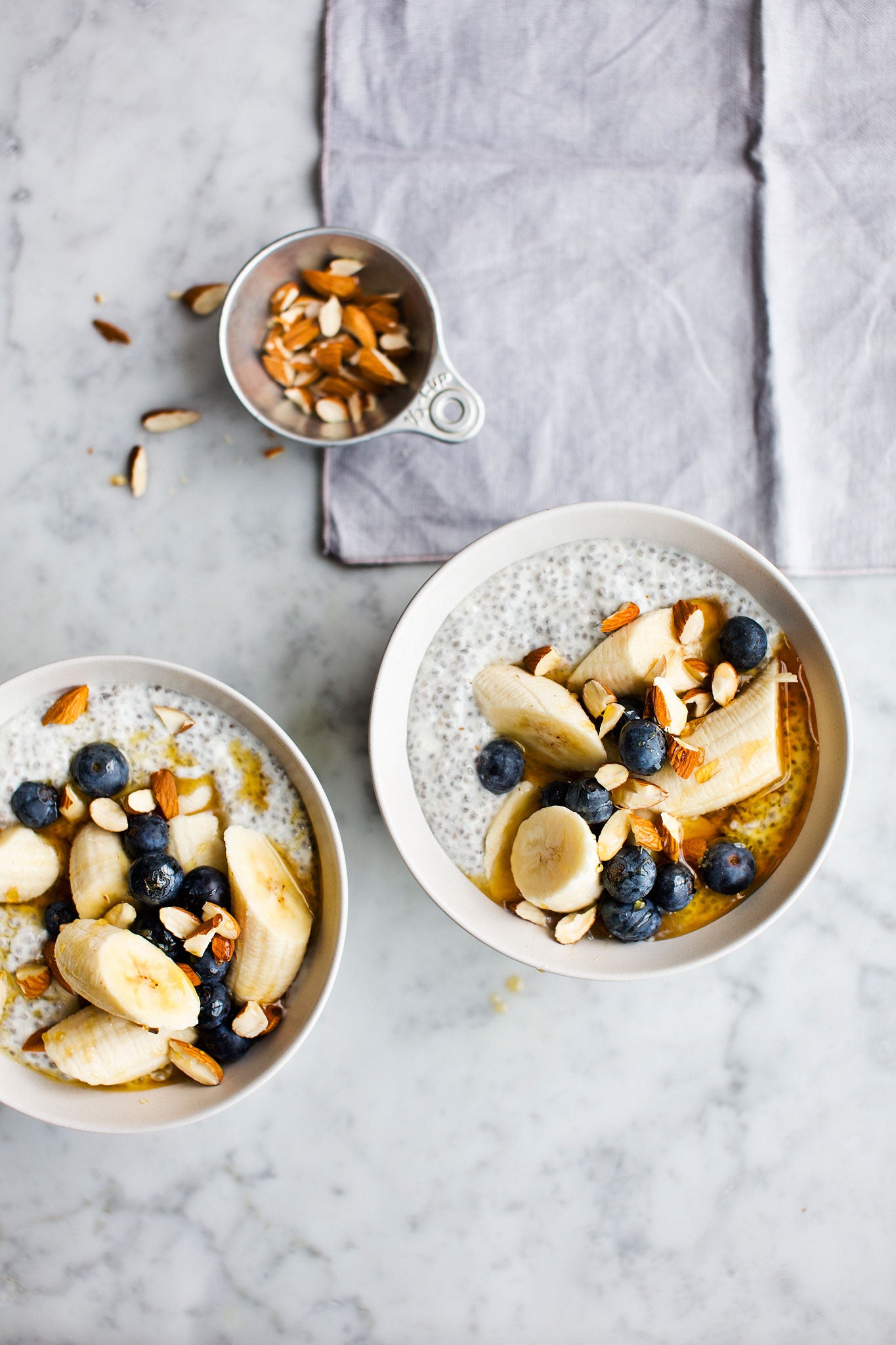 Banana, blueberries and chia seeds breakfast bowl with almonds