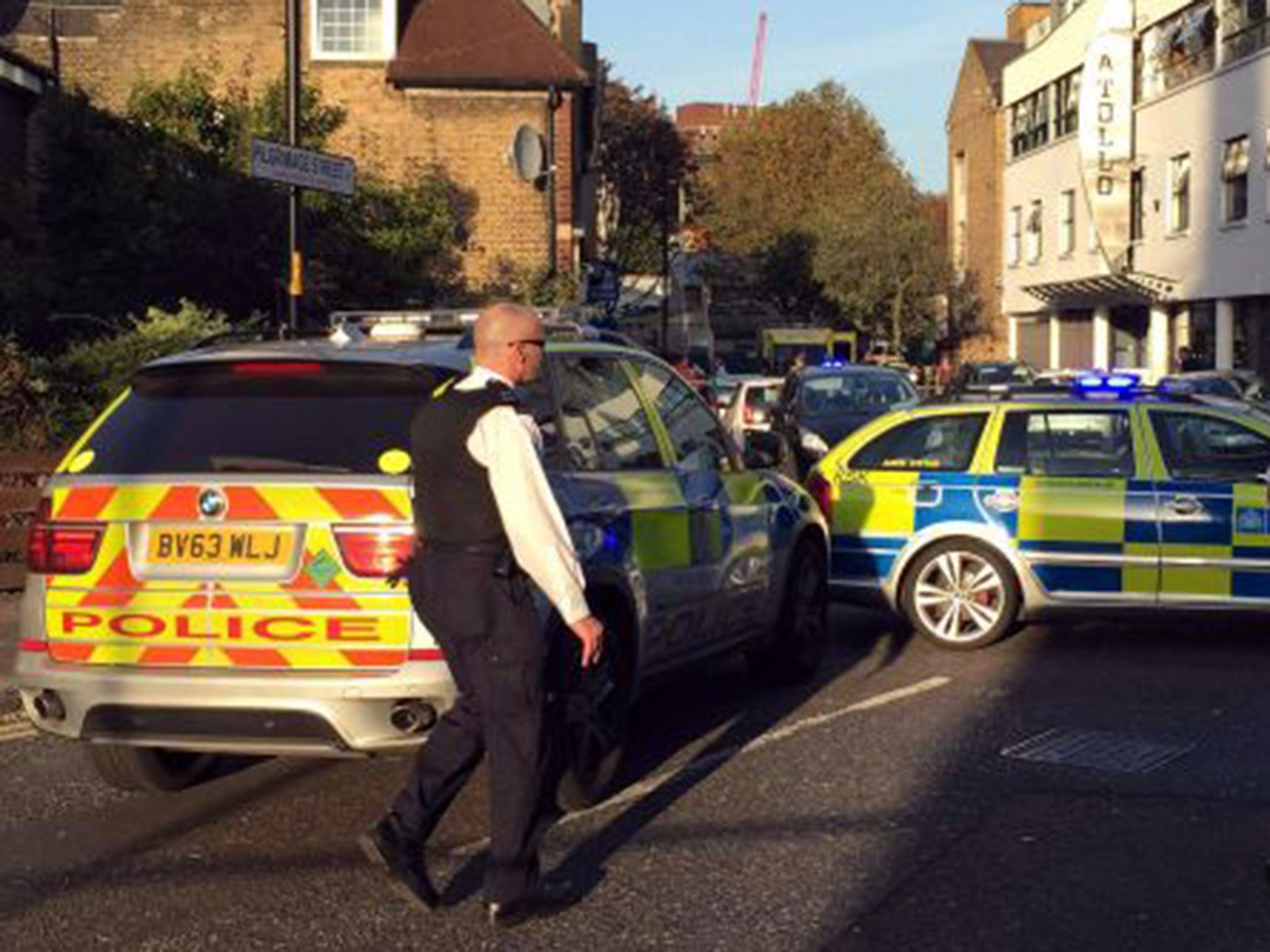 Police attend the scene where a teenager was stabbed to death, outside a convenience store in Pilgrimage Street, south London