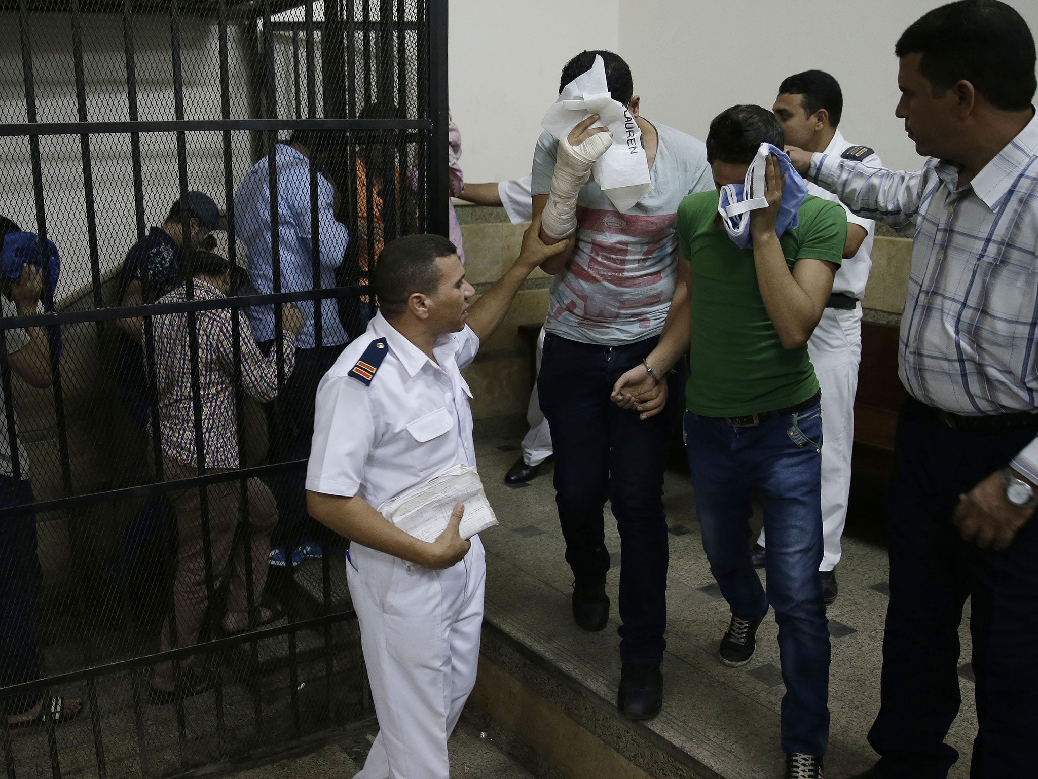 Eight Egyptian men leave the defendant's cage