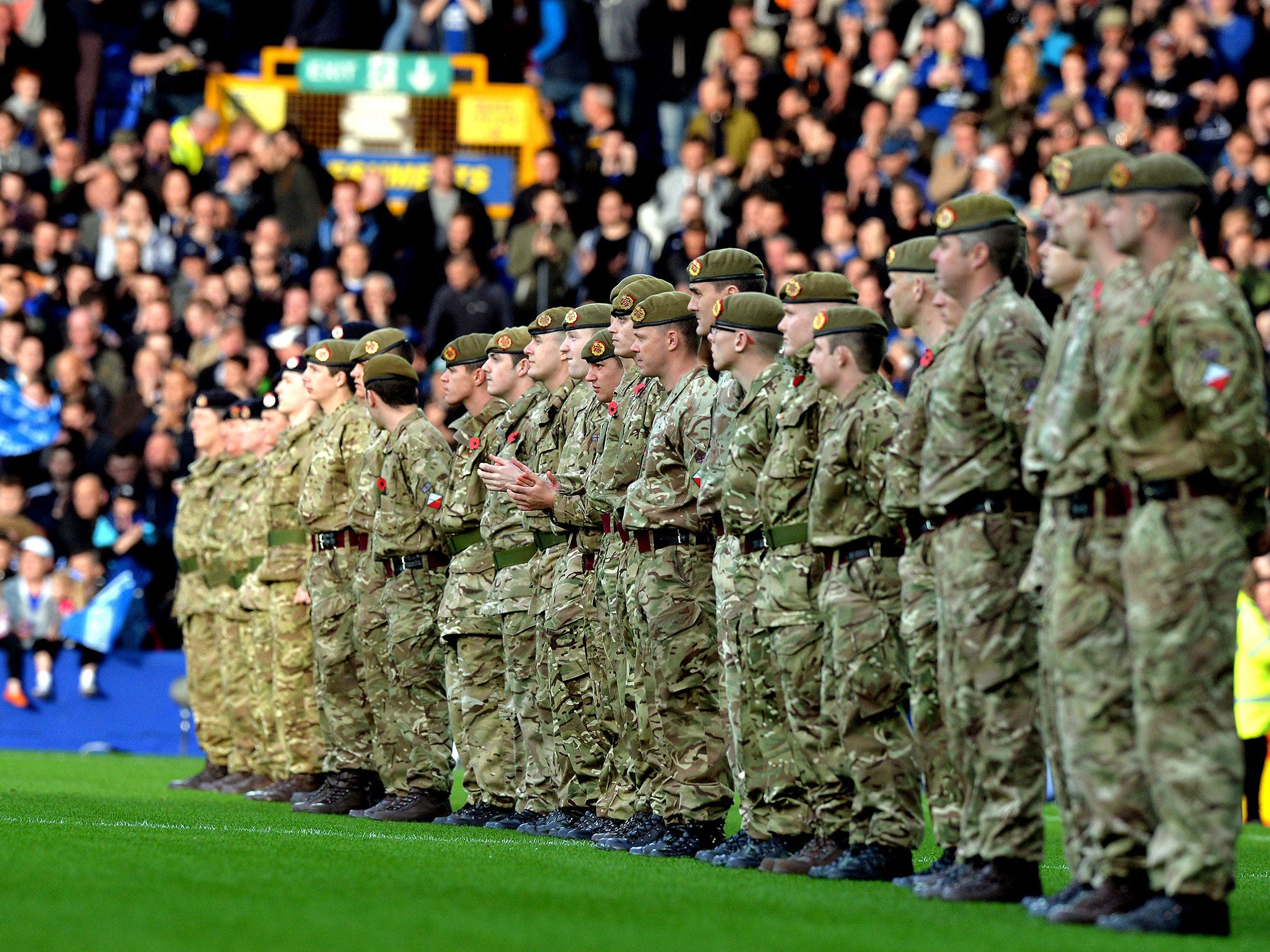 Members of the armed forces honour the minute's silence ahead of kick-off