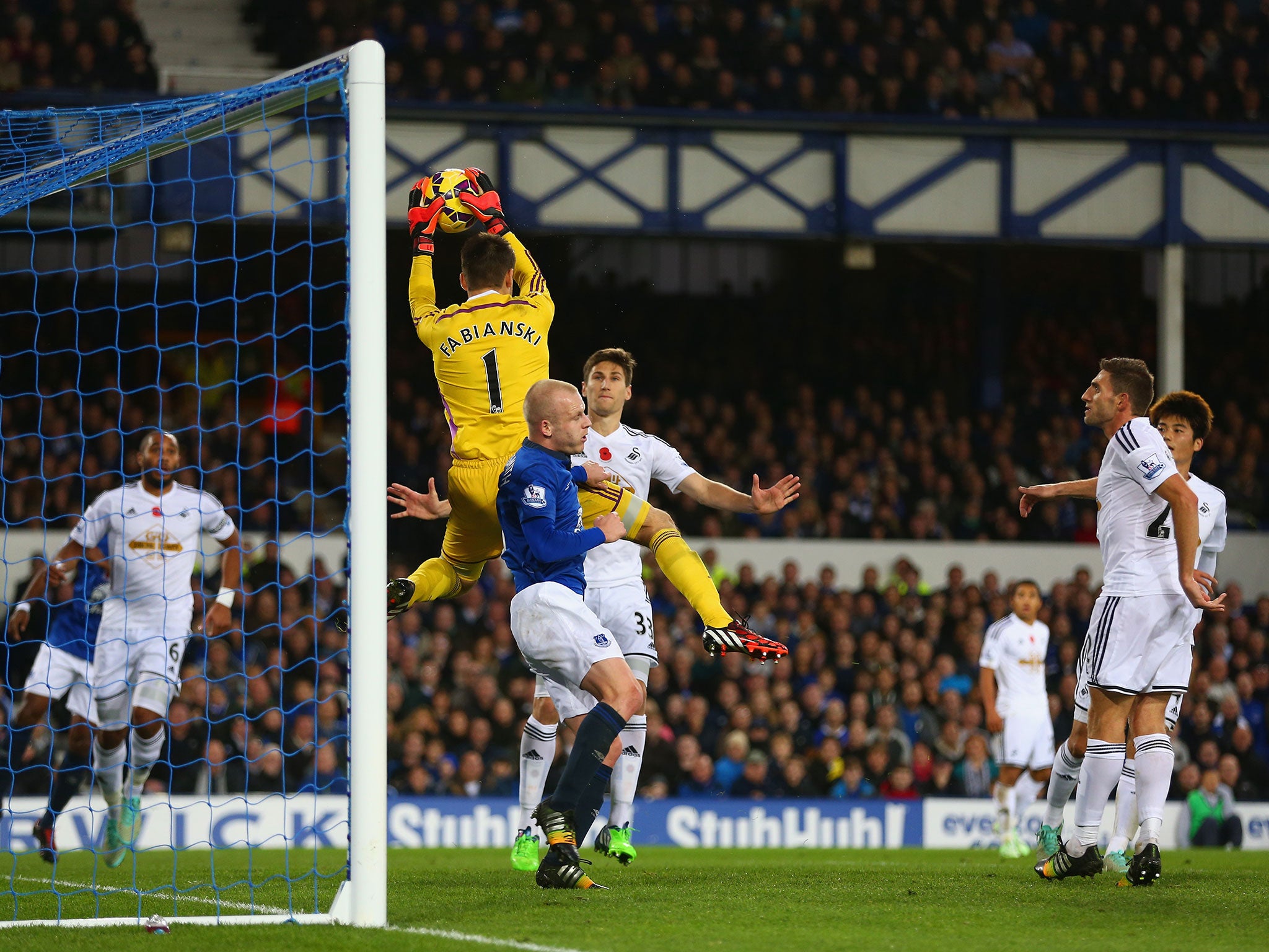 Lukasz Fabianski claims a high ball as Steven Naismith lurks dangerously