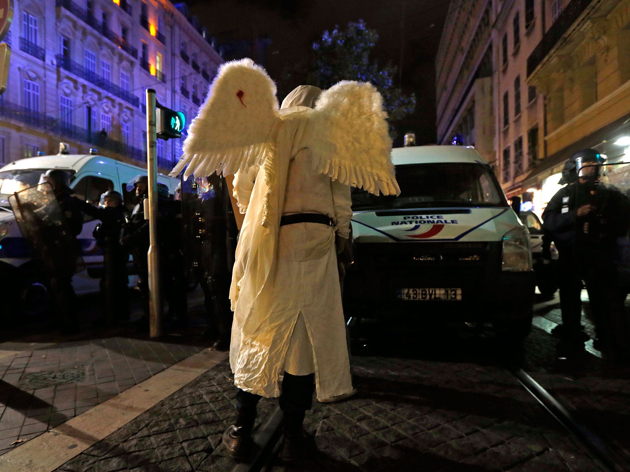 A demonstrator dressed as an angel faces French riot police officers during a rally in Marseille. People gathered to pay tribute to Rémi Fraisse, a 21-year-old demonstrator found dead after a rally against the Sivens dam