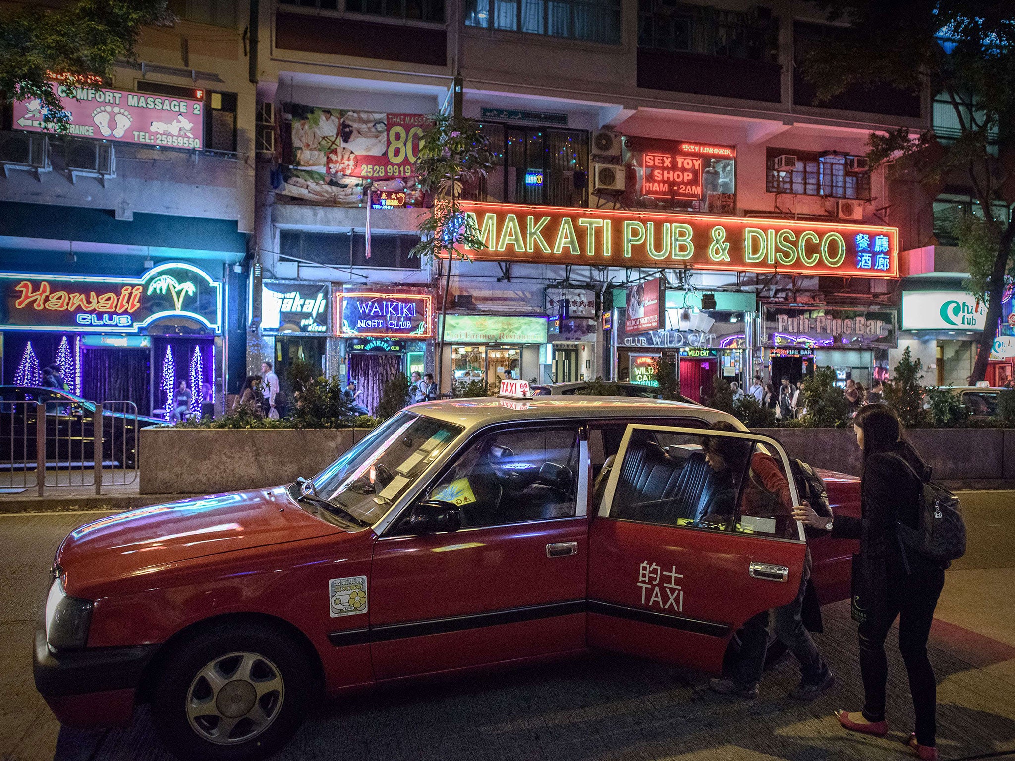 Passengers hail a taxi in Hong Kong’s Wan Chai district as a British banker appears in court charged with murdering two women