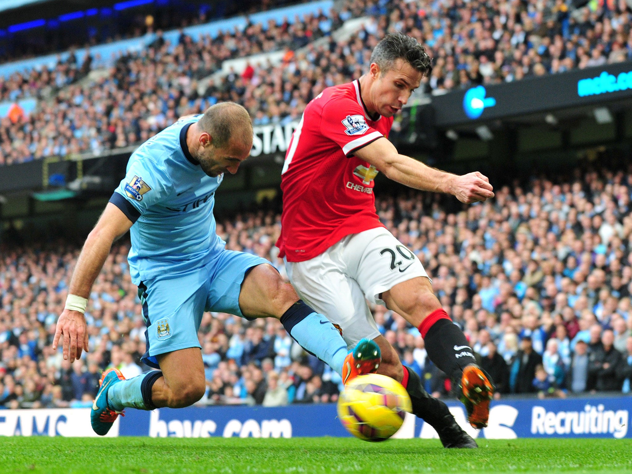 Pablo Zabaleta tackles Robin van Persie during the Manchester derby