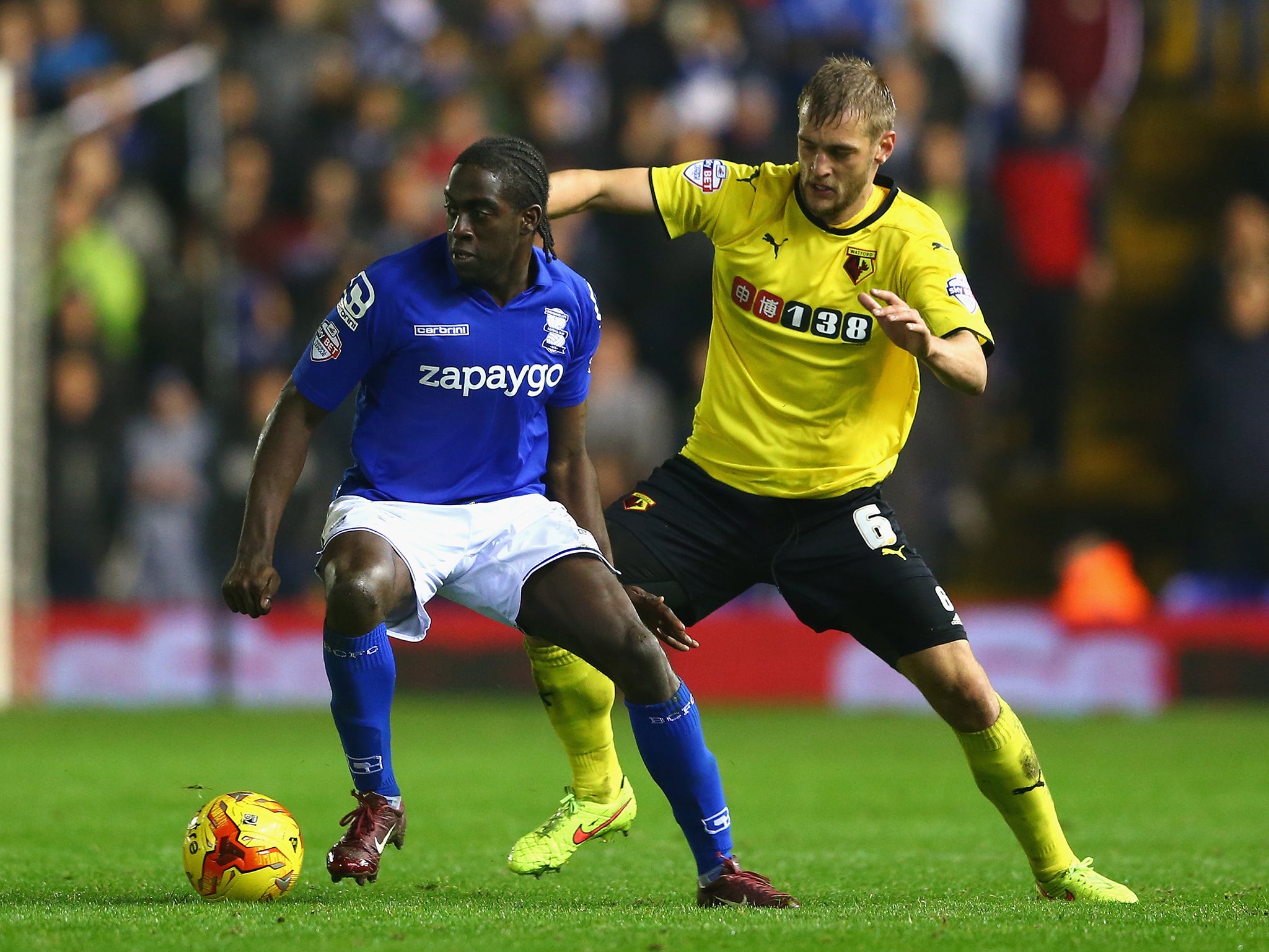 Clayton Donaldson (L) of Birmingham City is tracked by Joel Ekstrand (R) of Watford