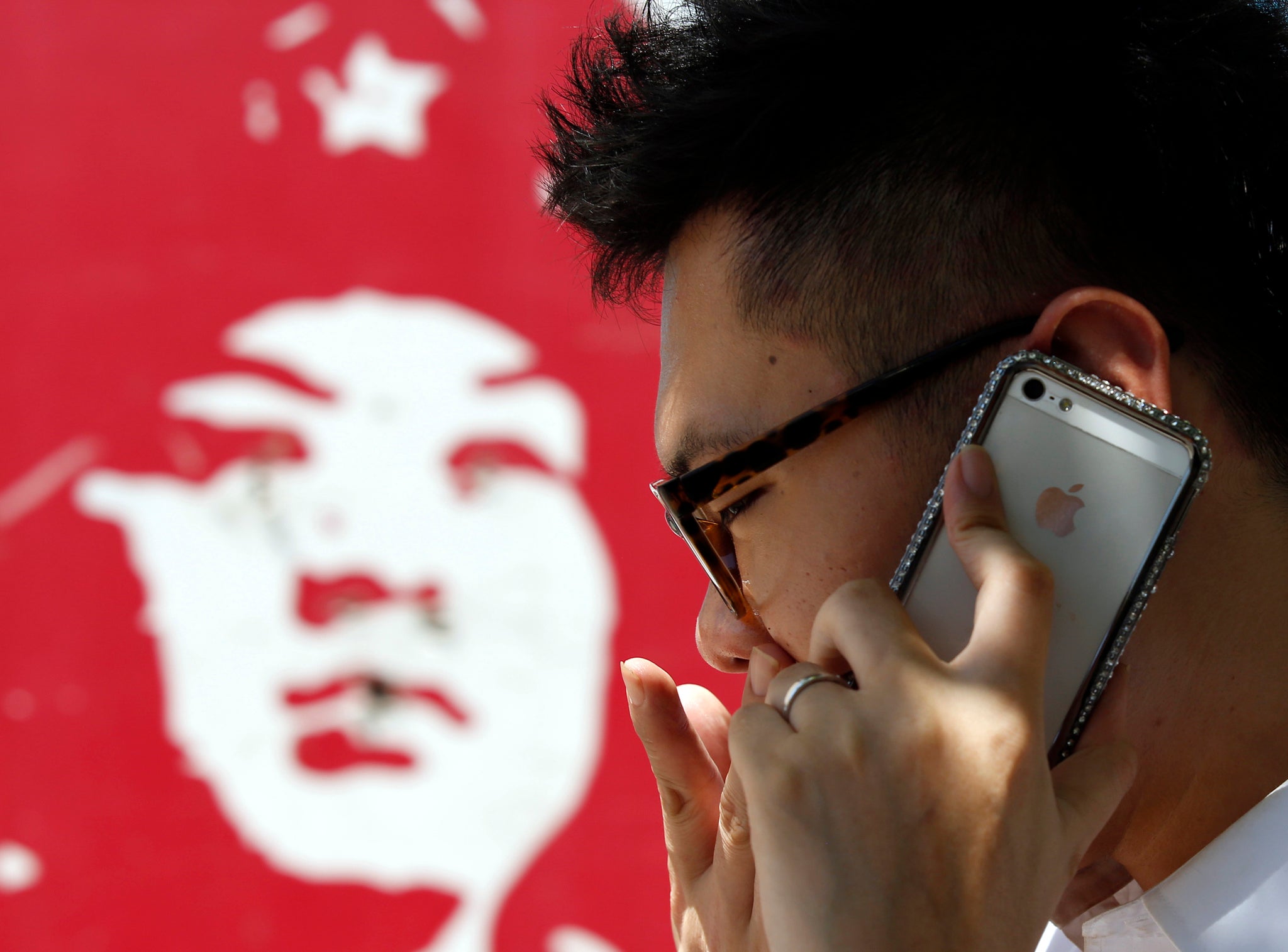 A man talks on an iPhone in Beijing July 24, 2013.