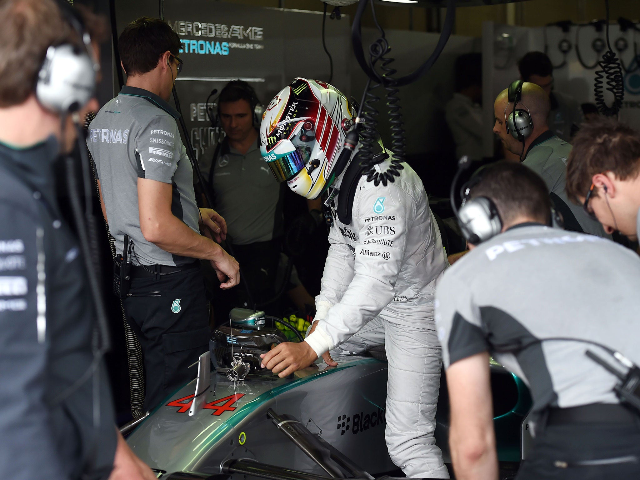 Lewis Hamilton climbs into his Mercedes cockpit