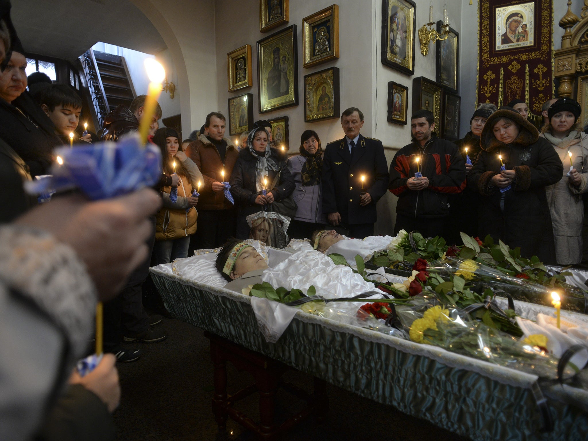 Families, teachers and schoolmates of 18-year-old Andrei Yeliseyev and 14-year-old Daniil Kuznetsov pray during a mourning ceremony in an Orthodox church in Donetsk