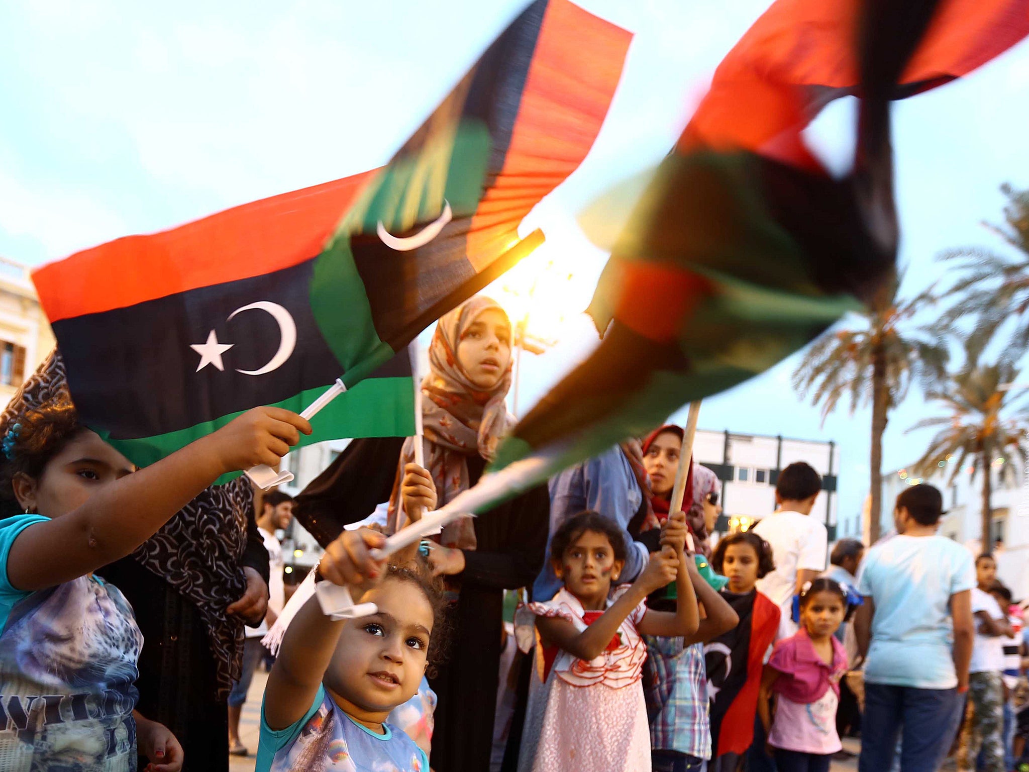 Libyan women and young girls wave the national flag during celebrations for the third anniversary of the 2011 Libyan revolt in Tripoli last month