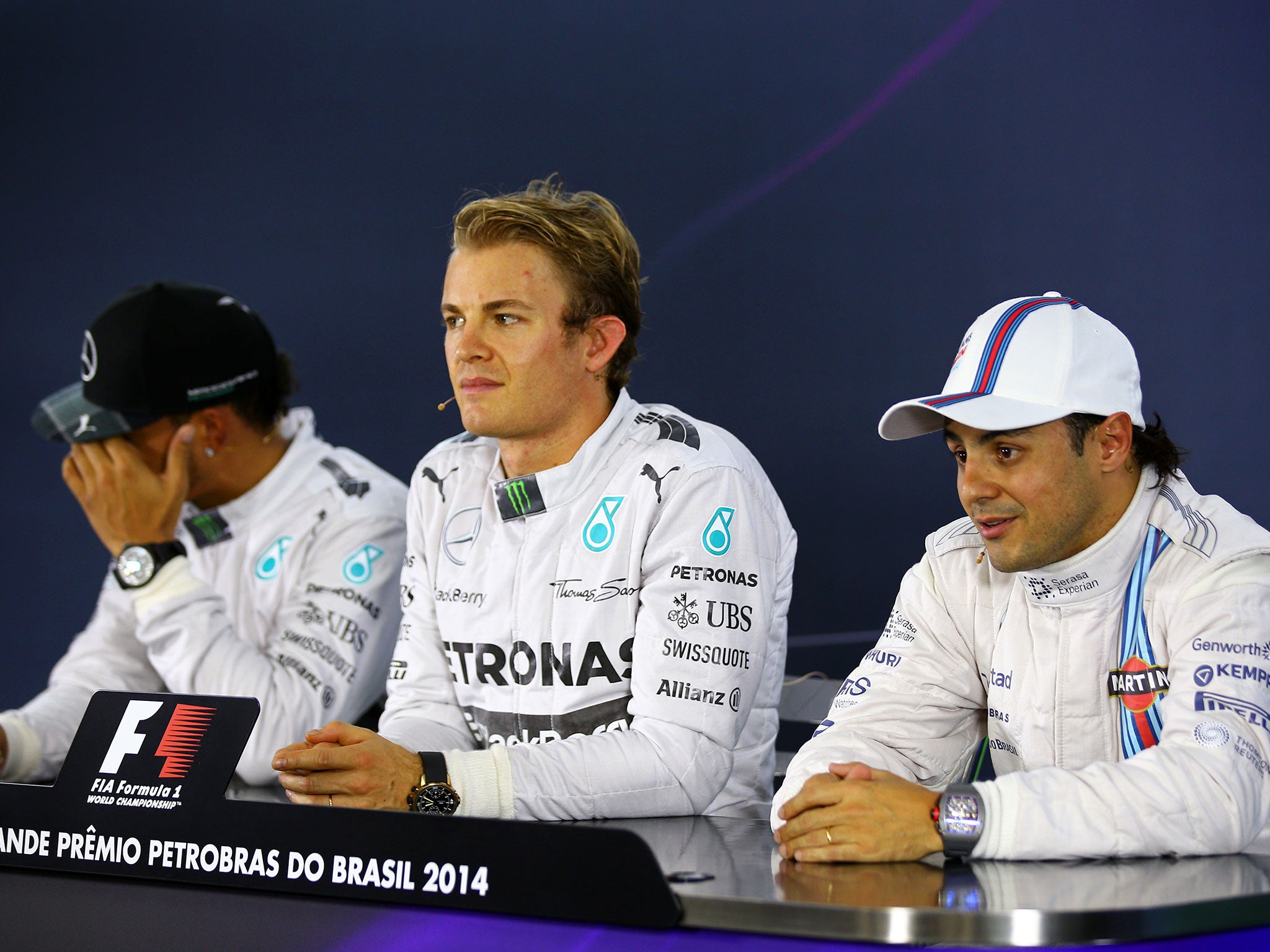 Lewis Hamilton looks away while Nico Rosberg and Felipe Massa answer questions during the post-qualifying press conference