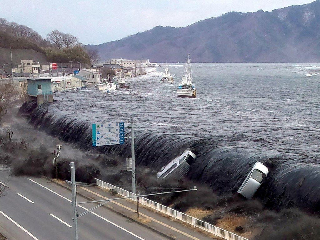 The tsunami breeching an embankment and flowing into the city of Miyako shortly after a 9.0 magnitude earthquake hit the region of northern Japan