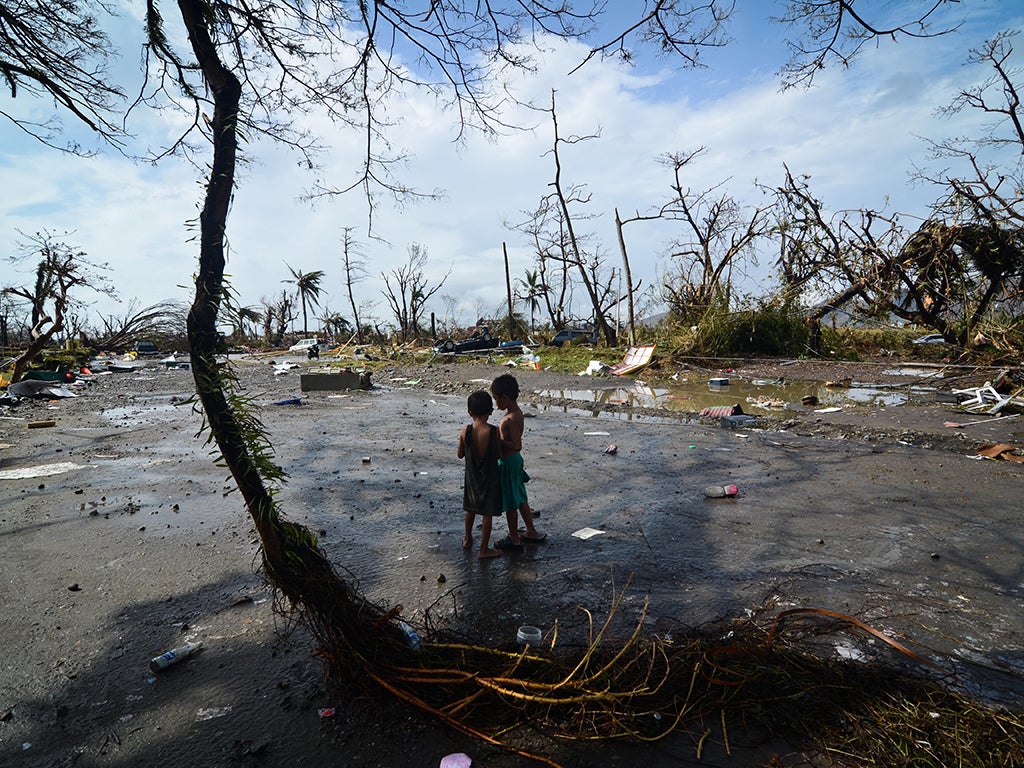 Two young boys look at the devastation in the aftermath of typhoon Haiyan