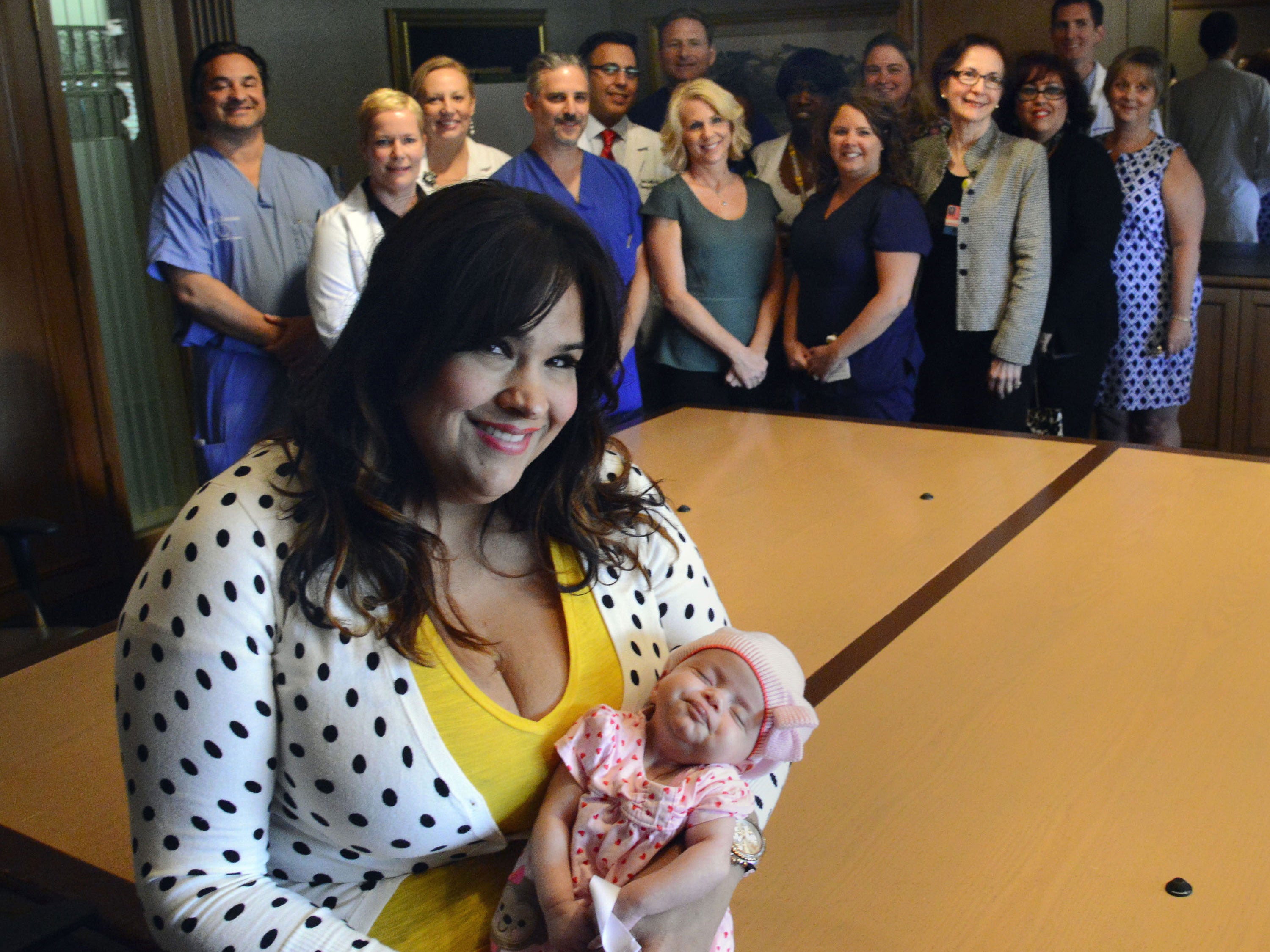 Ruby Graupera-Cassimiro holds her newborn daughter, Taily, a month after surviving having no pulse for 45 minutes