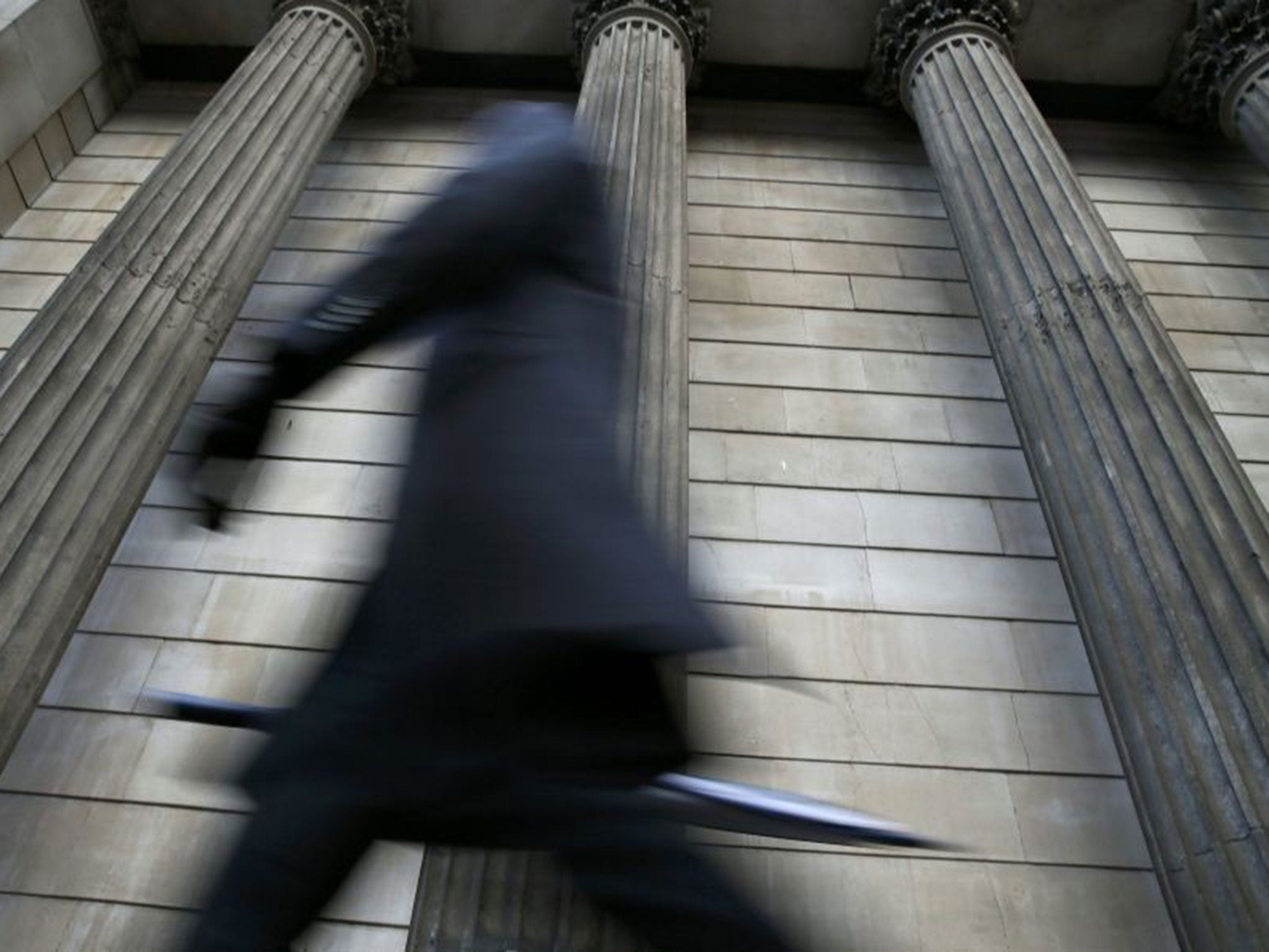 A person walks through the City of London during the early morning rush hour in London