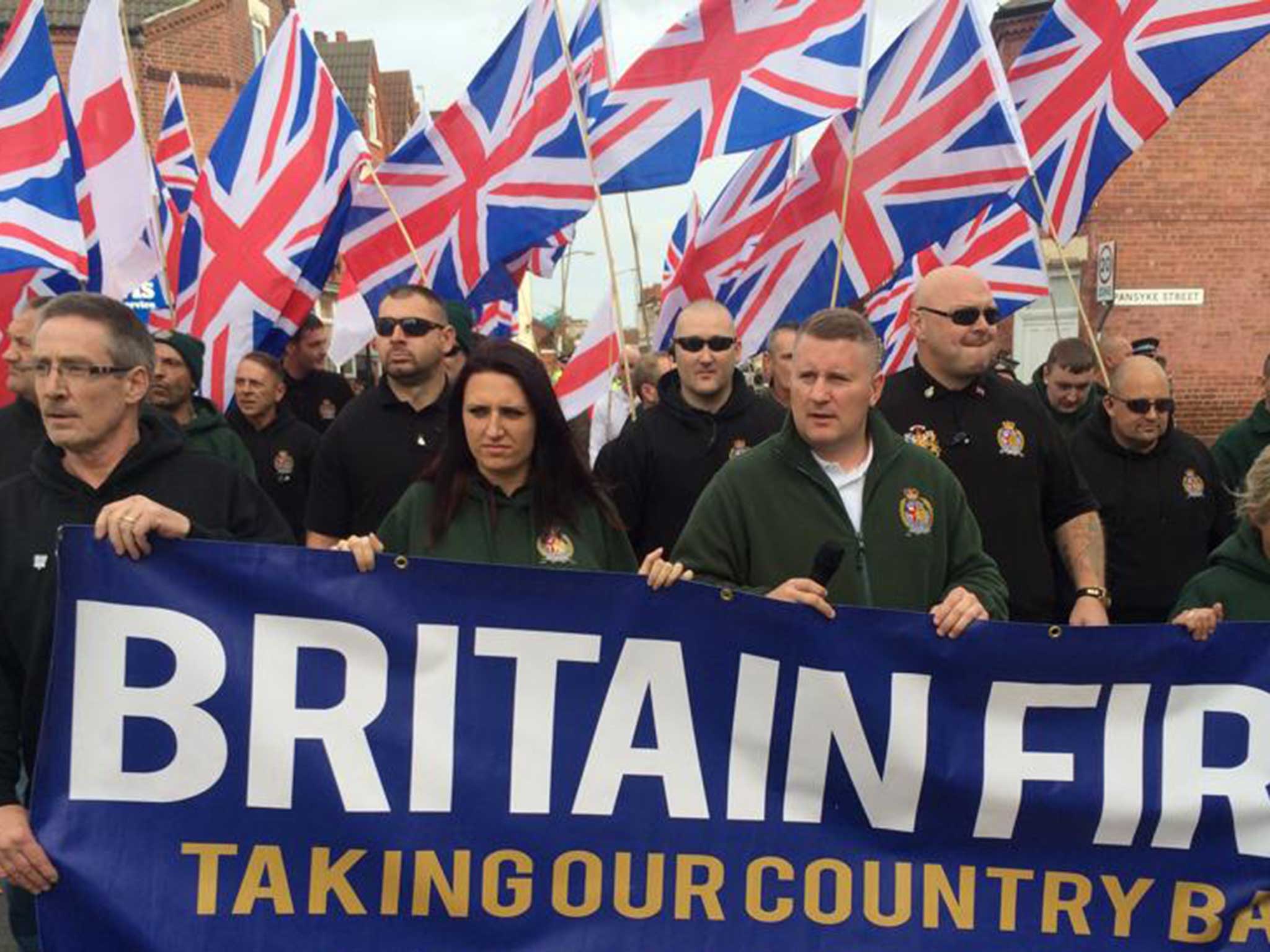 Britain First marching at a rally - Jayda Fransen, in green, can be seen with party leader Paul Golding at the front