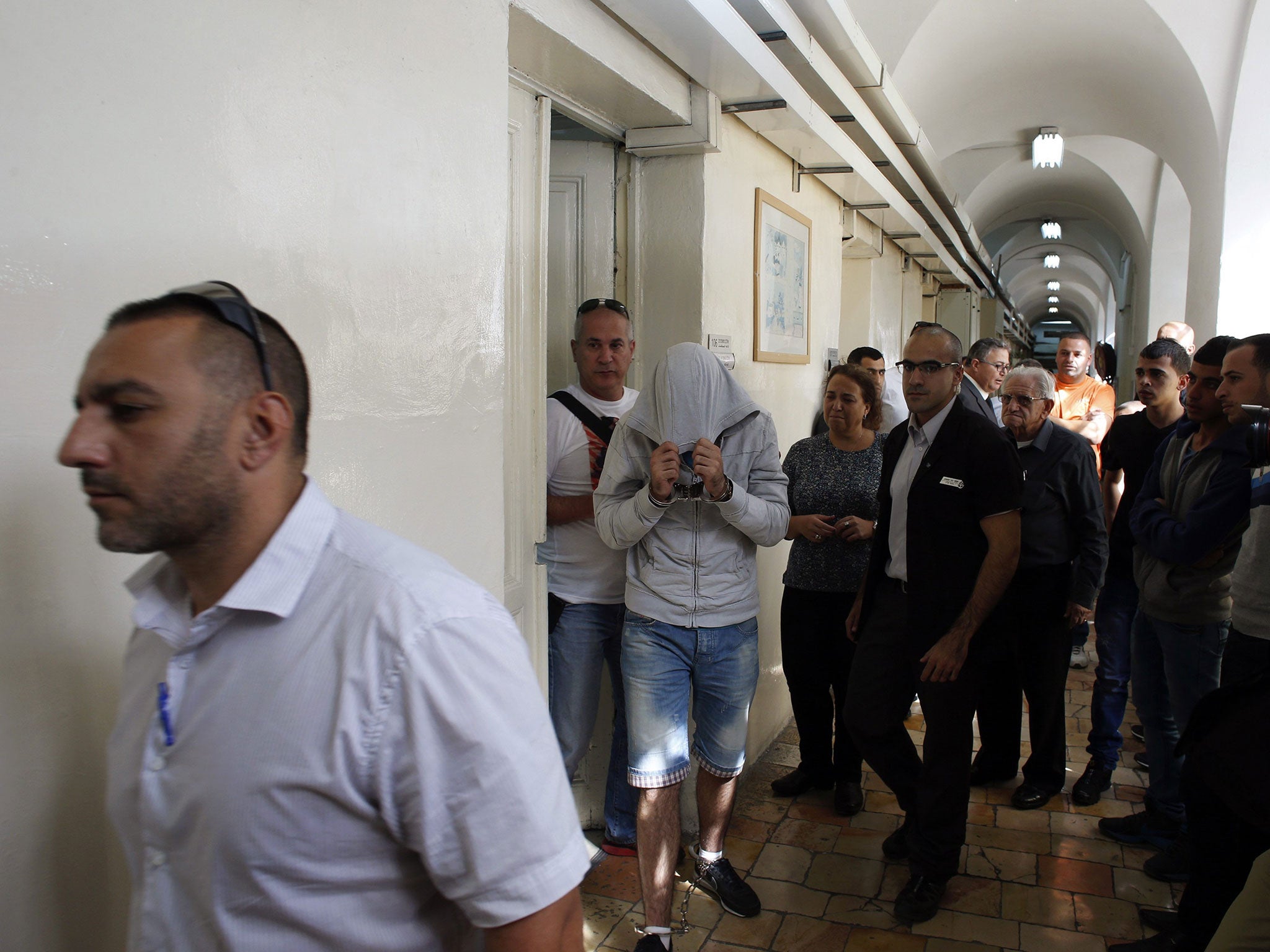 Border policeman covers his head as he arrives at a remand hearing