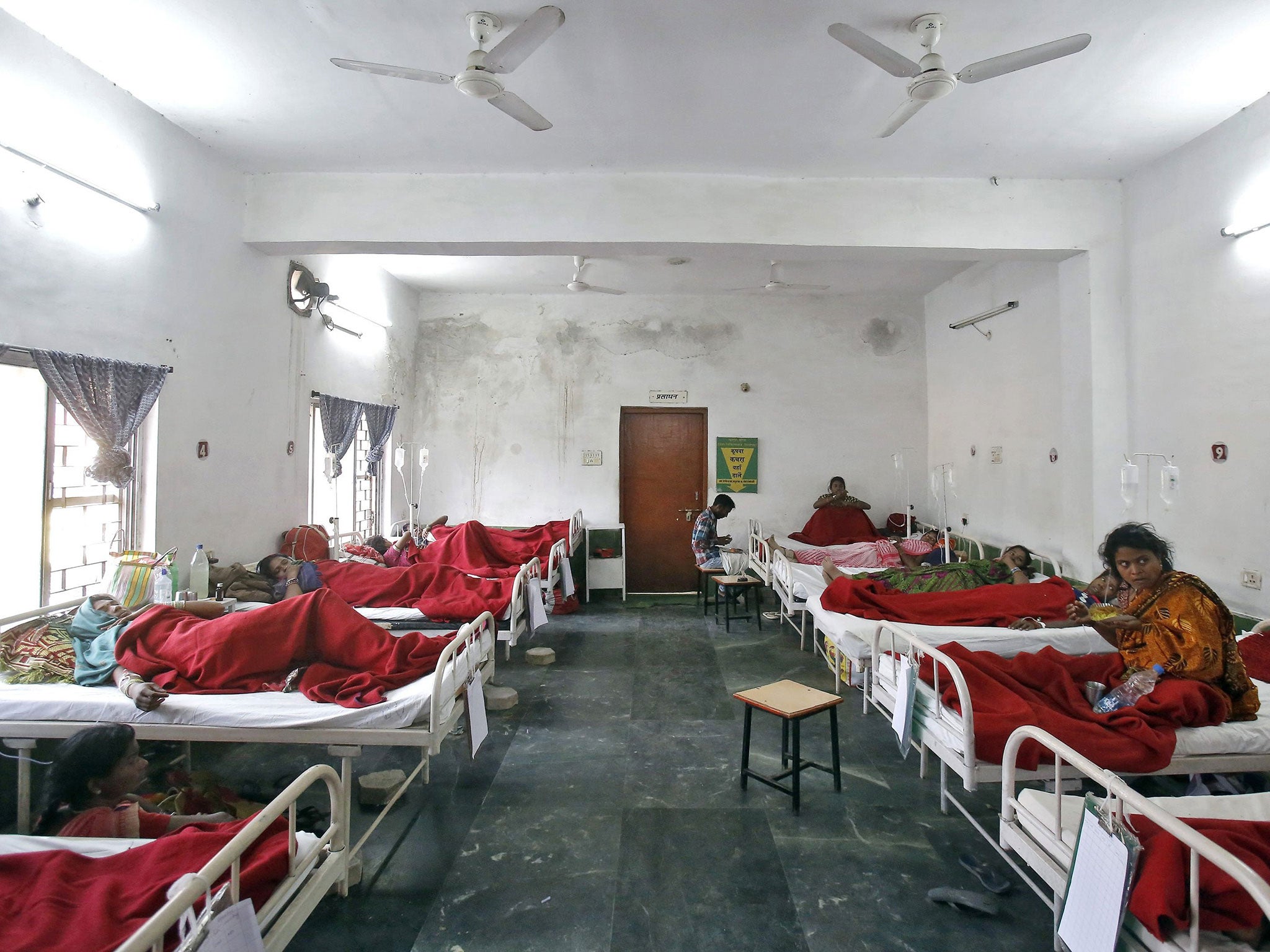 Women, who underwent a sterilization surgery at a government mass sterilisation "camp", lie in hospital beds for treatment