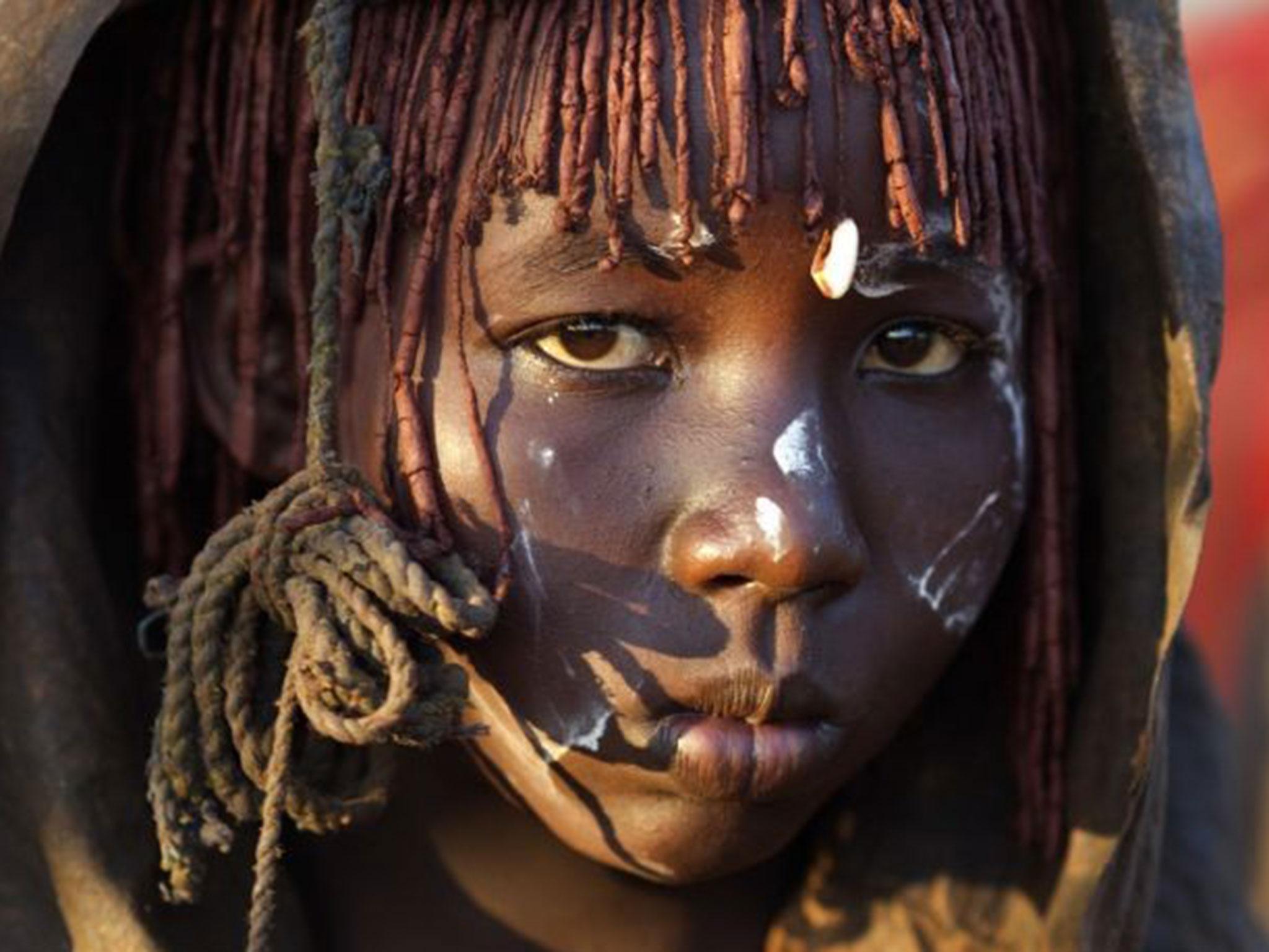 A Pokot woman holds a razor blade after performing a circumcision on four girls