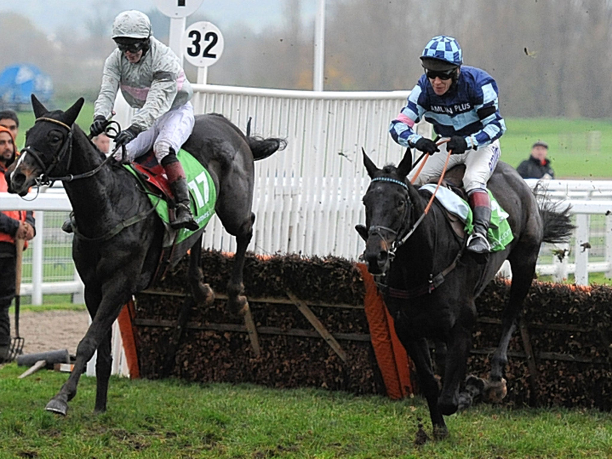 Garde La Victoire (right), ridden by Richard Johnson, jumps the last fence to win the Greatwood Hurdle at Cheltenham