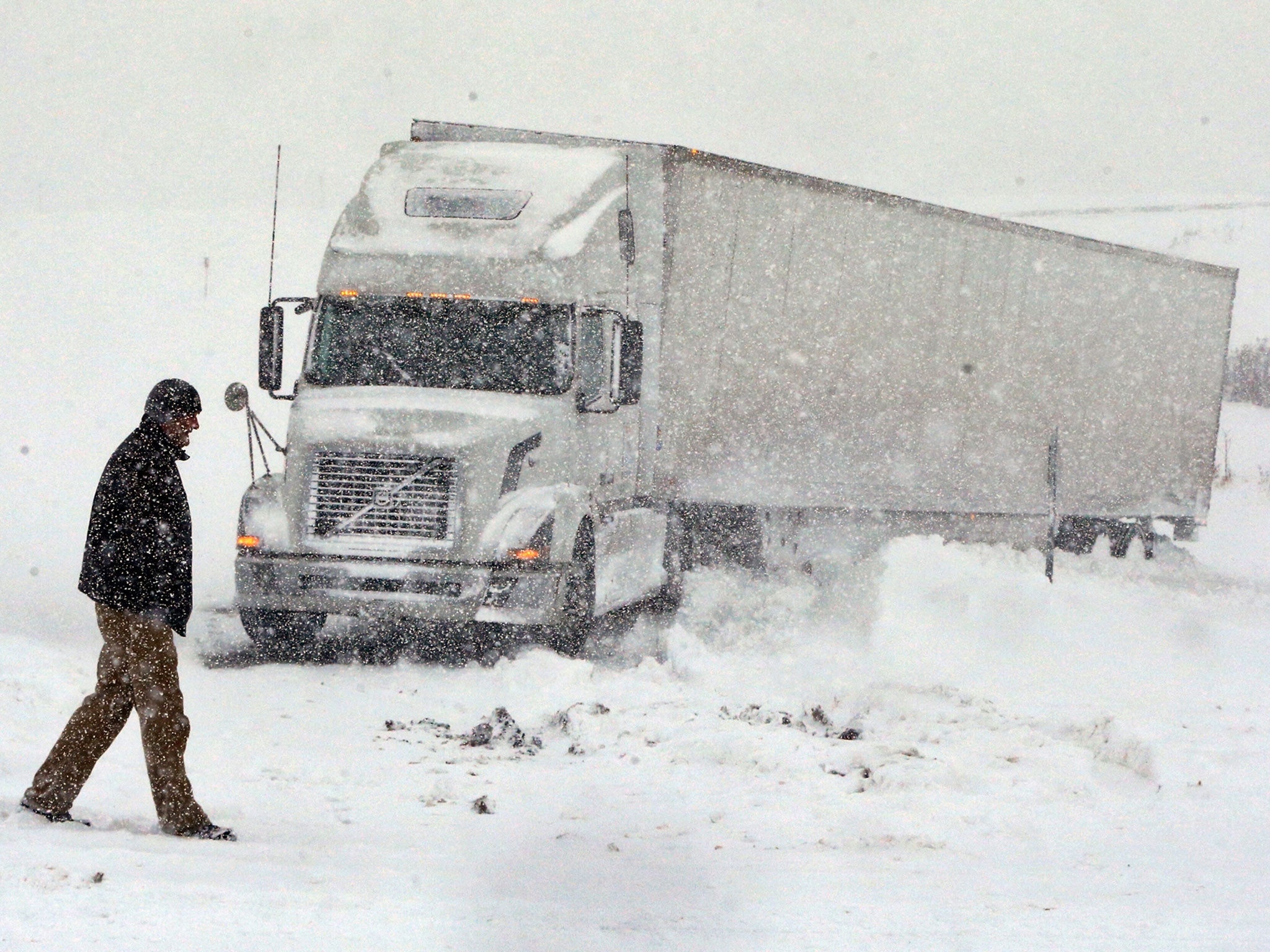 Omer Odovsc walks in front of his tractor trailer that got stuck in Boston