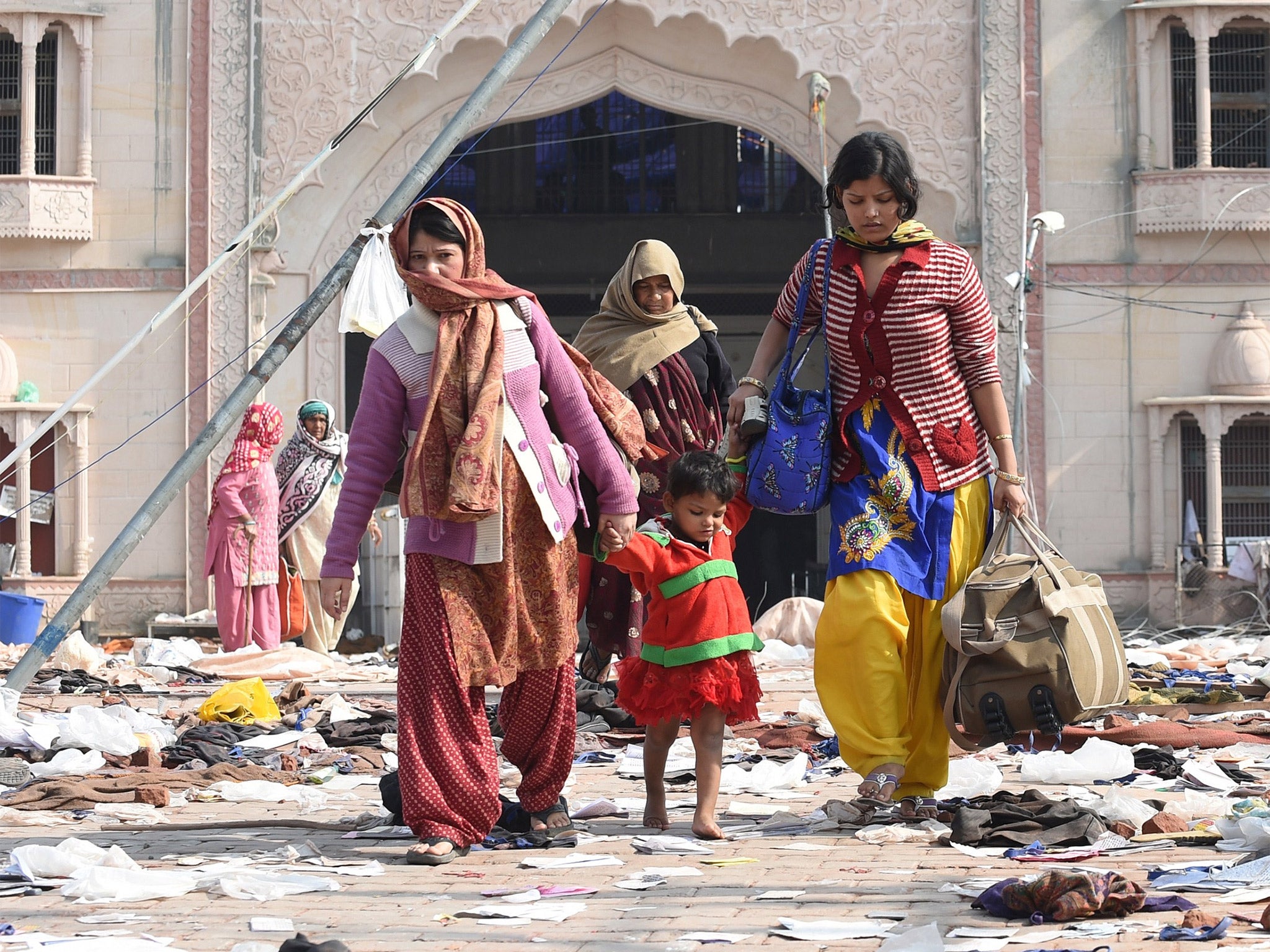 Followers leave the ashram of Sant Rampal in Hisar, India, where police discovered five bodies after storming the wanted guru’s headquarters