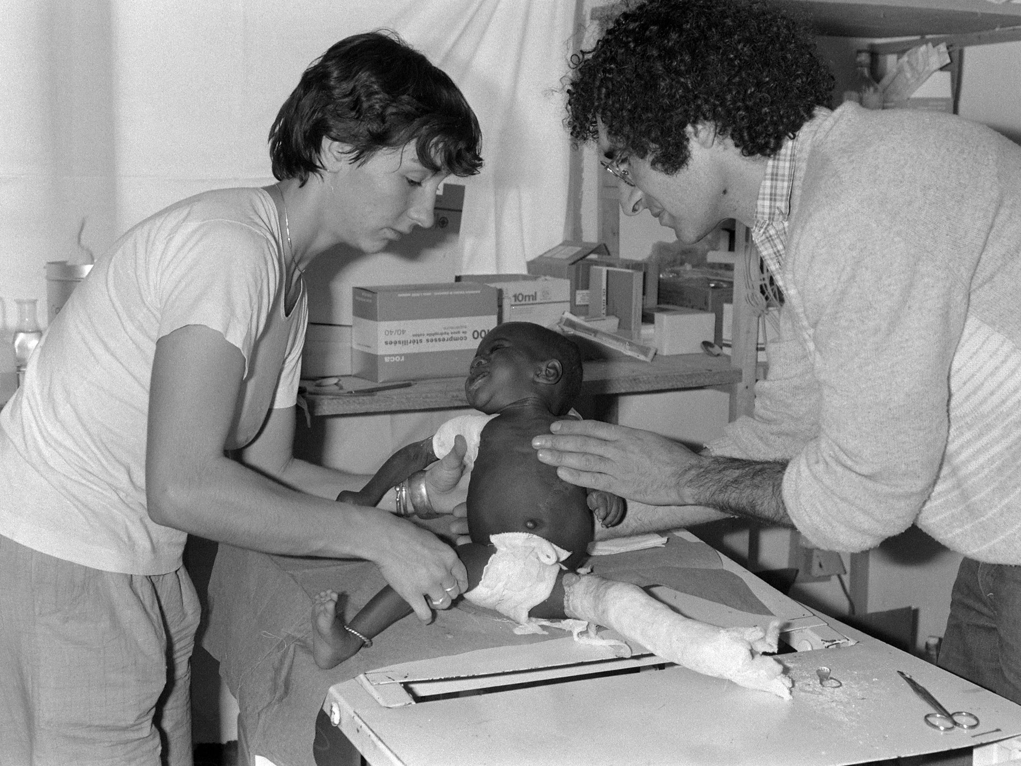 French doctor Xavier Emmanuelli (R) and an other female doctor take care of a child in their hospital in N'Djamena, Chad