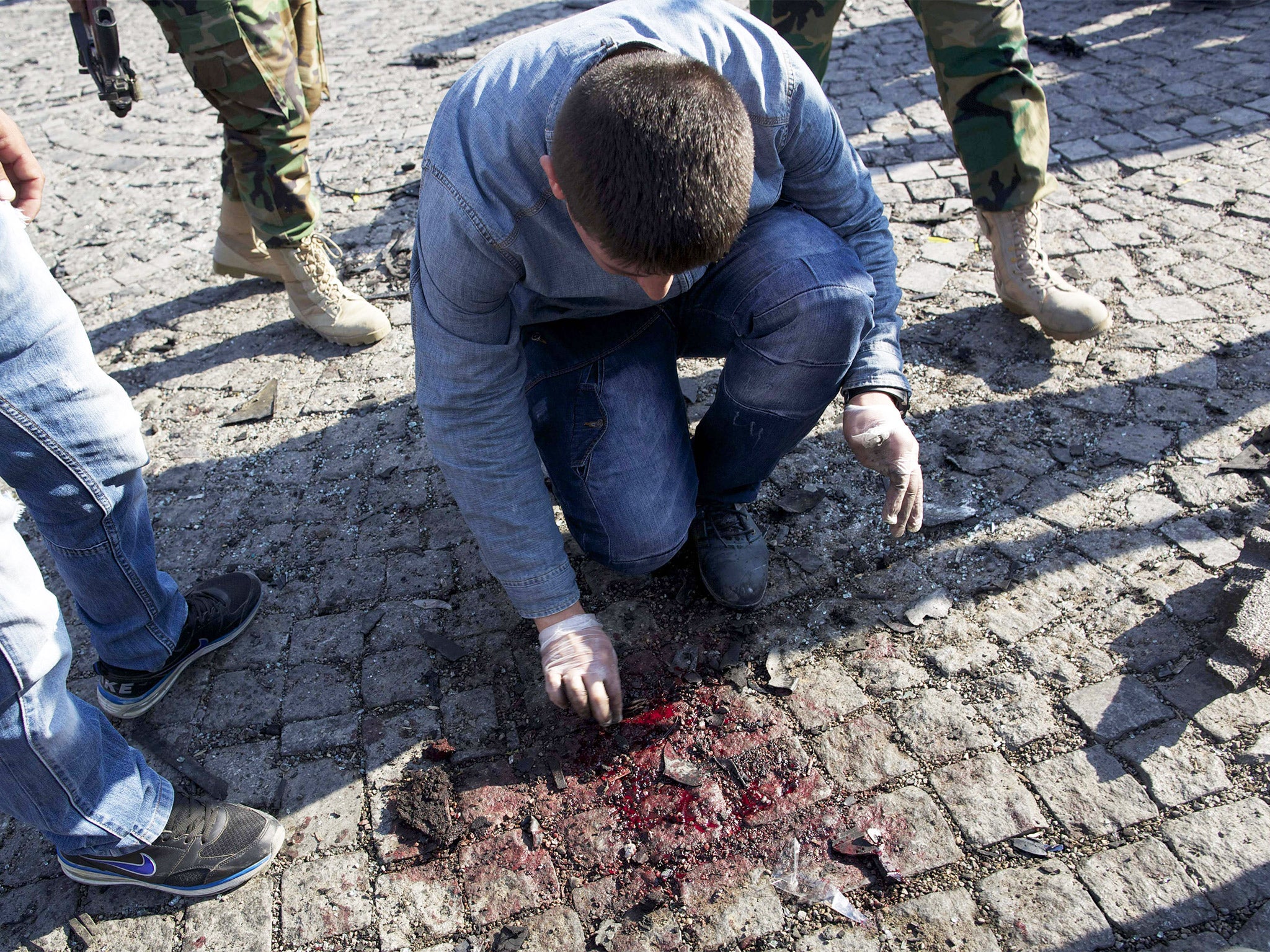 An investigator works at the site of a suicide attack