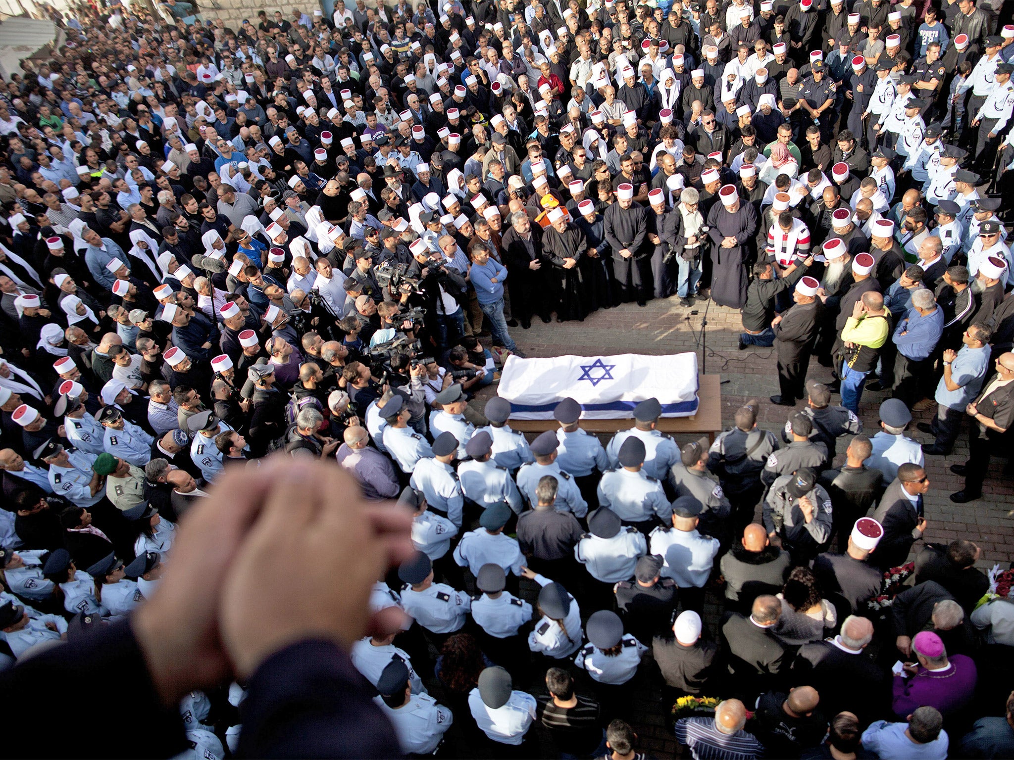 Mourners attend the funeral of Druze policeman Zidan Sif, who died of his wounds after two Palestinian cousins armed with knives and a gun stormed a Jerusalem synagogue