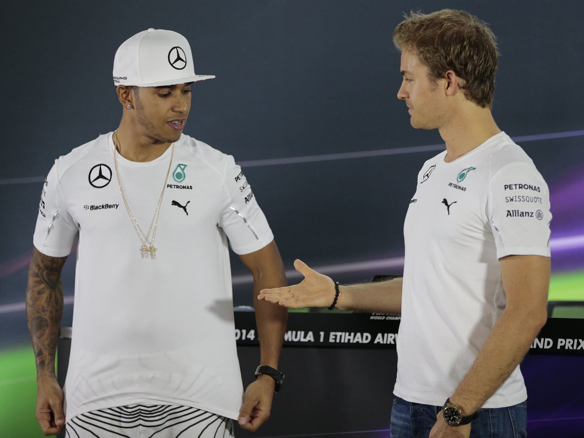 Nico Rosberg (right) offers Mercedes team-mate and Formula One title rival Lewis Hamilton his hand during a news conference in Abu Dhabi yesterday