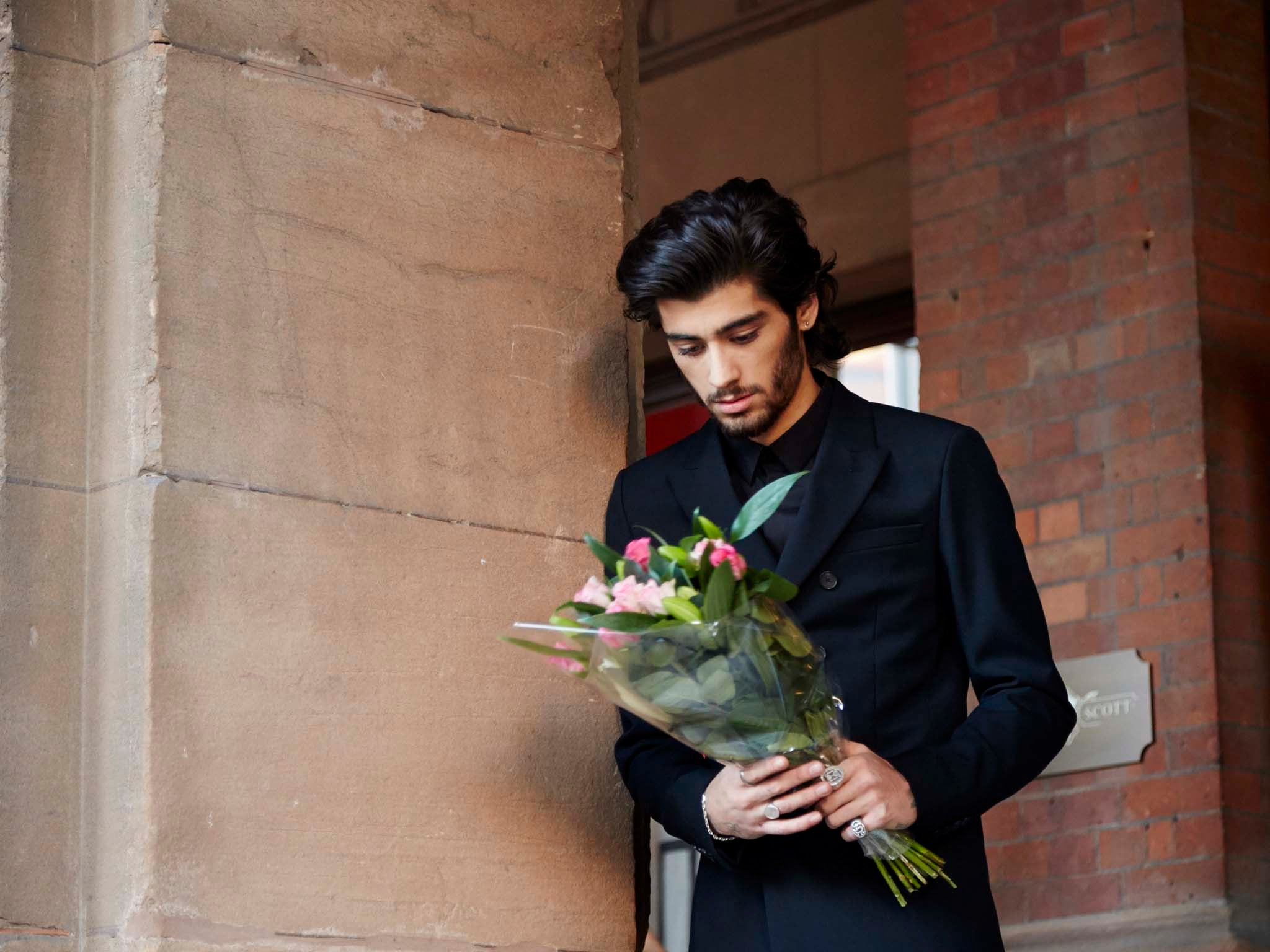 One Direction's Zayn Malik gazes at a bouquet of flowers in the 'Night Changes' music video