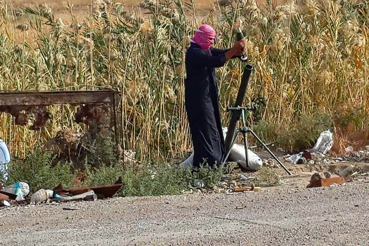 An Isis fighter loads a mortar shell during clashes with Iraqi security forces in the city of Ramadi on Saturday 22 November.