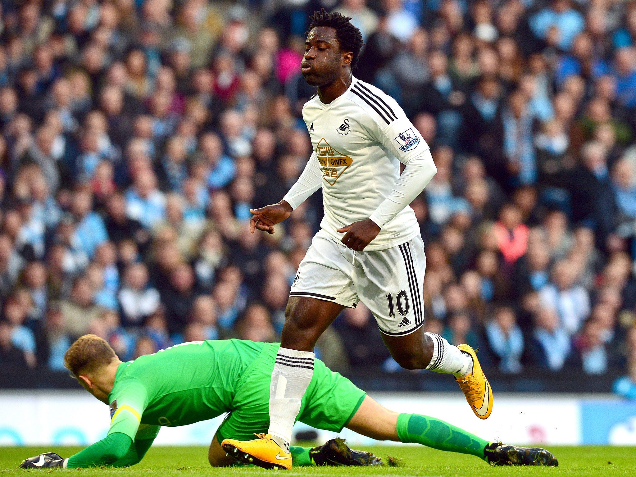 Bony celebrates scoring for Swansea as Joe Hart looks on in despair