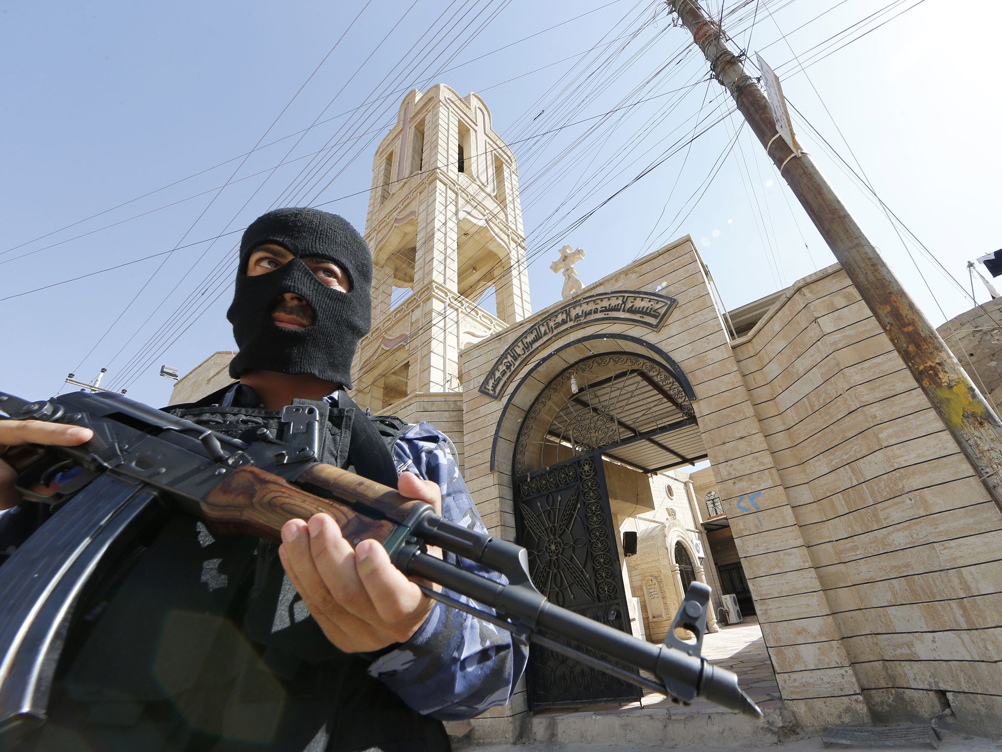 An Iraqi security officer guards a church in Bartala, after Mosul fell