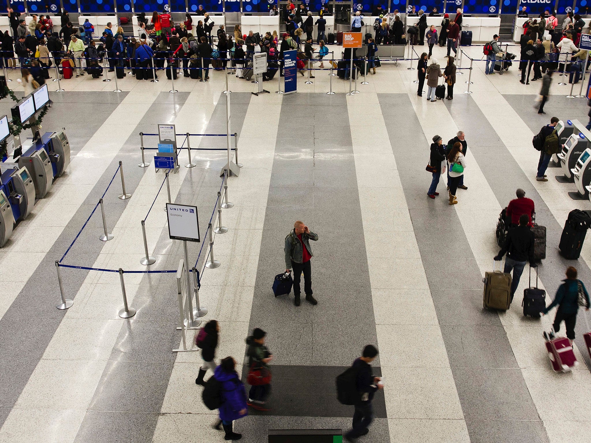 A naked man crashed through the ceiling of Boston Logan International Airport before biting an OAP's ear and attempting to strangle him