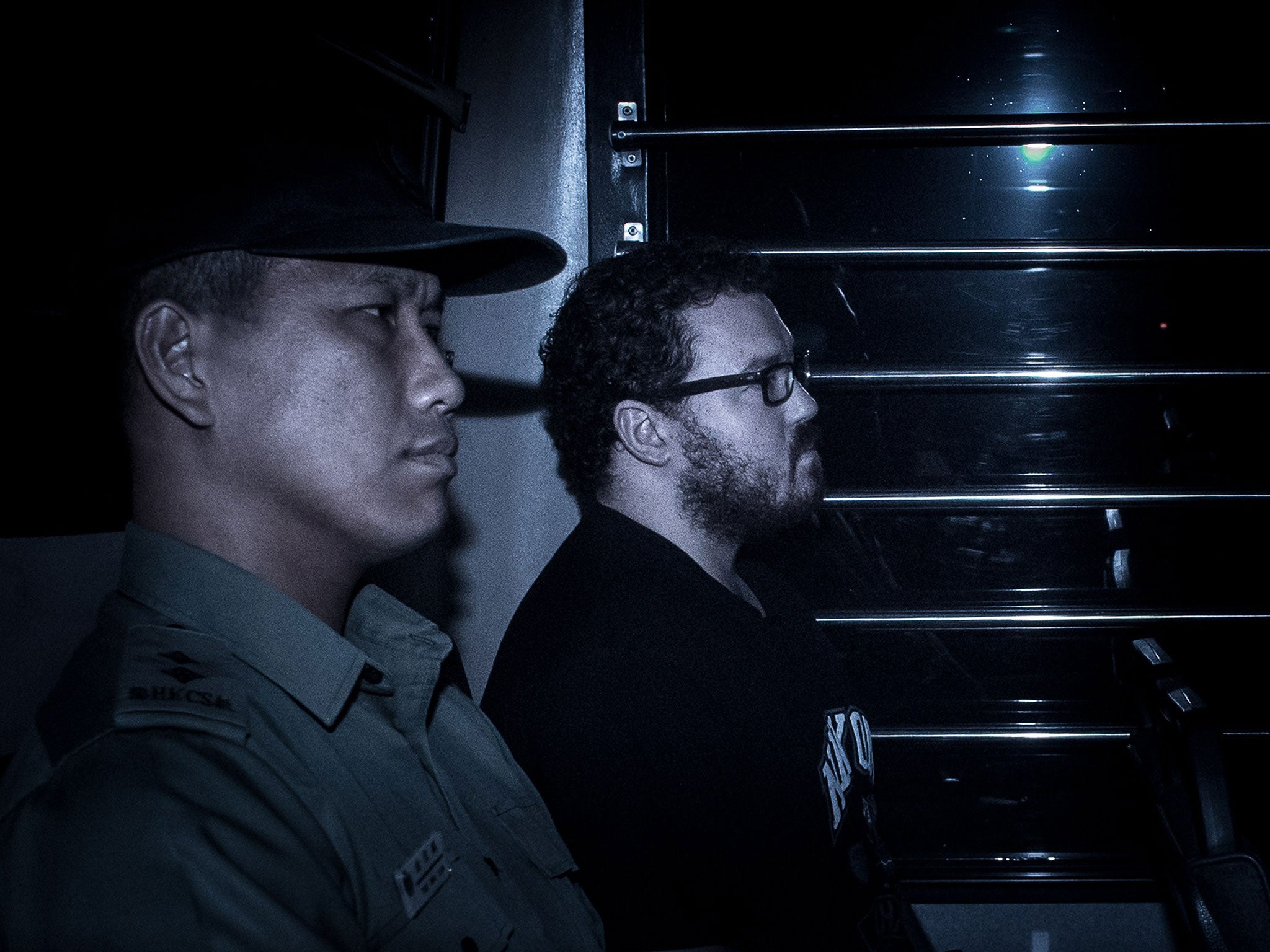 British banker Rurik Jutting (C) sits in a prison van as he arrives at the eastern court in Hong Kong on November 24, 2014