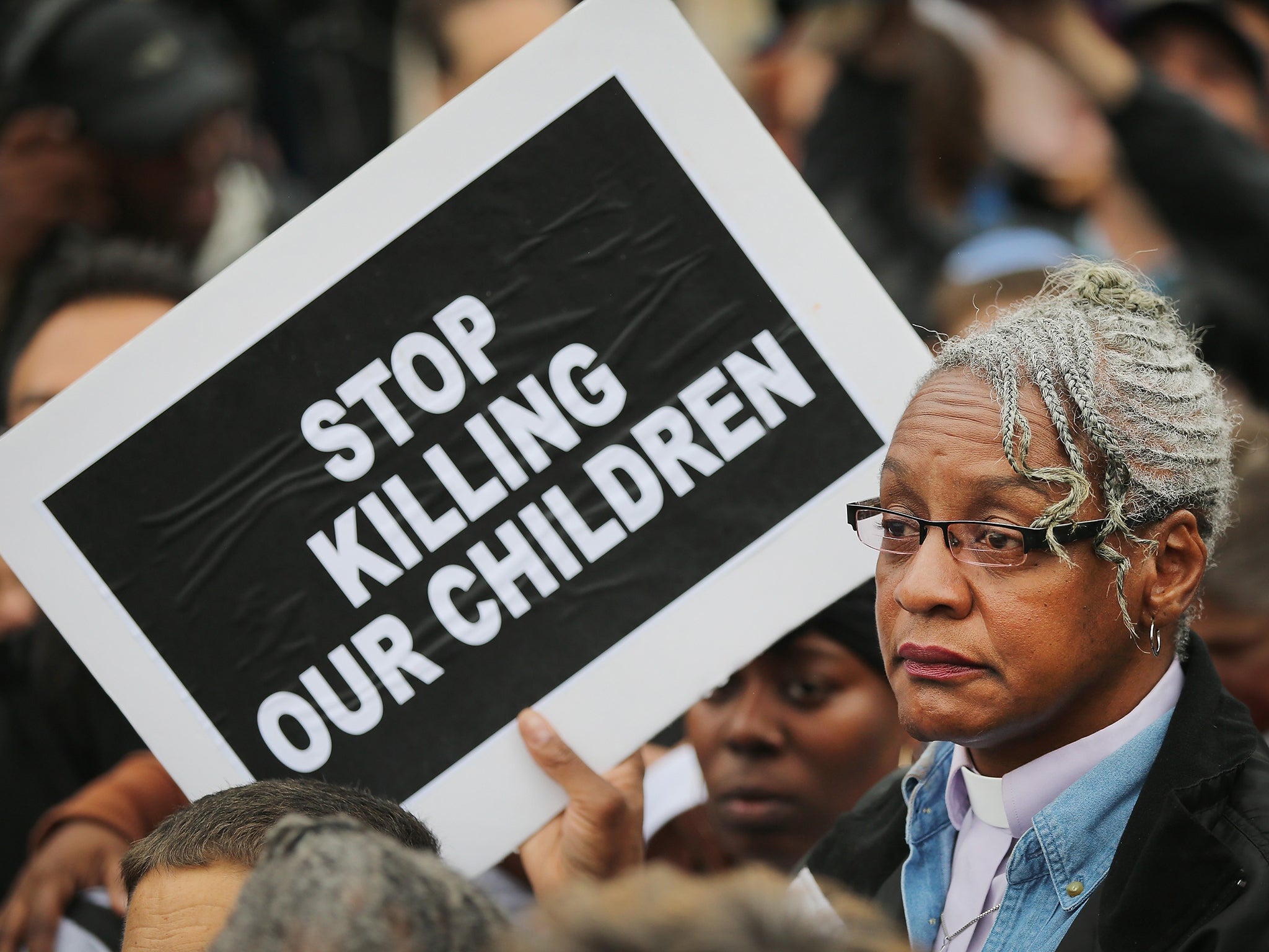 A member of the clergy protests outside Ferguson police station