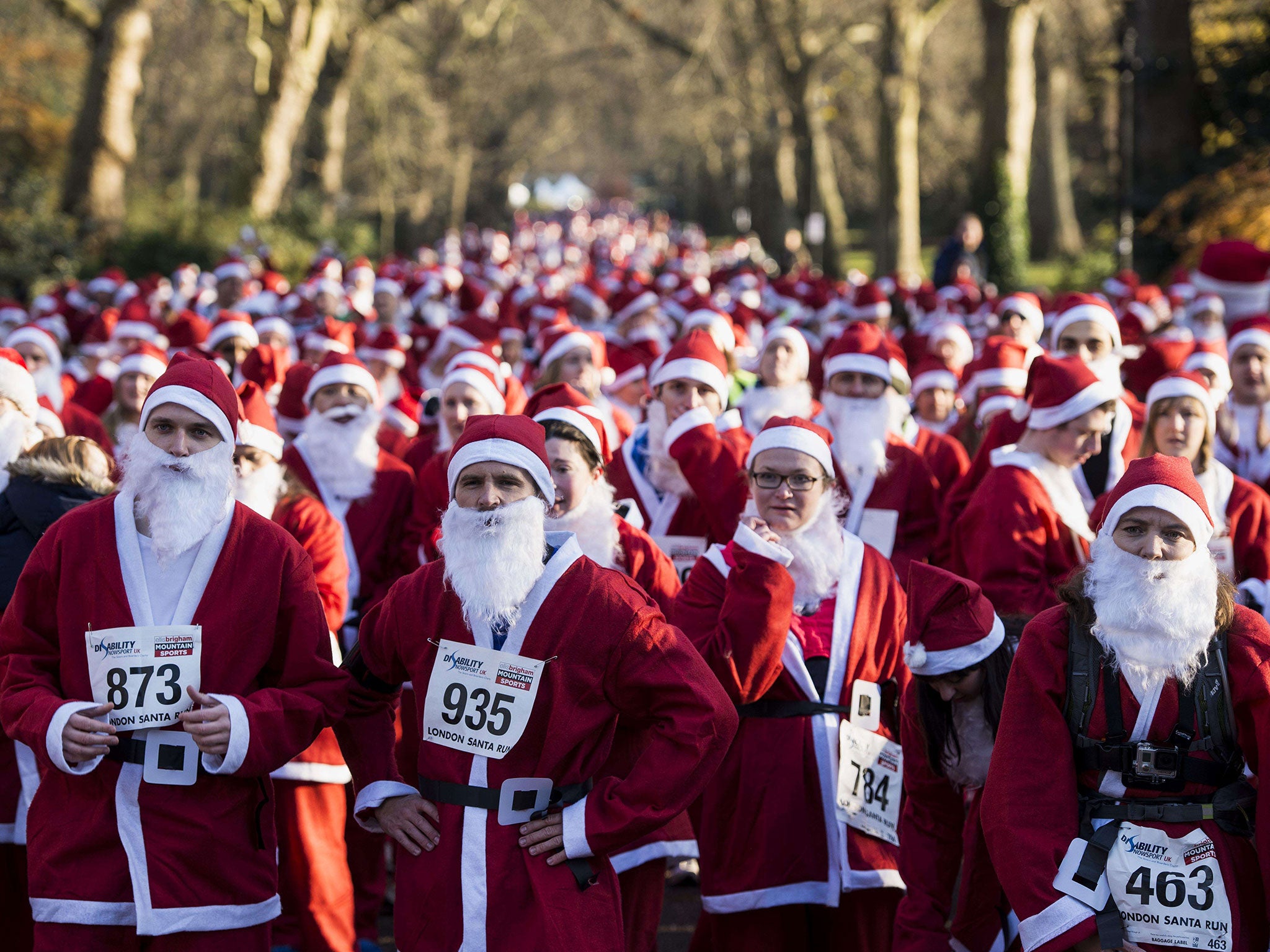 Charity runners dressed as Father Christmas await the start of the 'Santa Run' charity fun run in Battersea Park in London. Hundreds of participants dressed in Santa suits and white beards ran through Battersea park in aid of winter sports charity Disability Snowsport in this 6km festive fun run