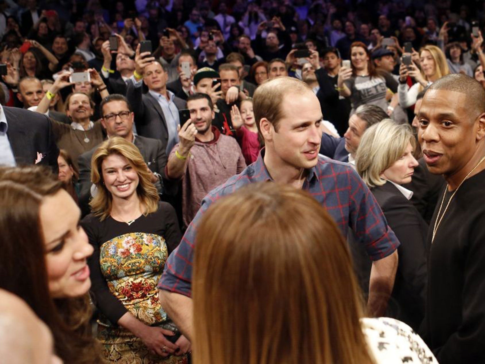 Prince William talks with Jay-Z , as the Duchess of Cambridge, chats with Beyonce during an NBA basketball game