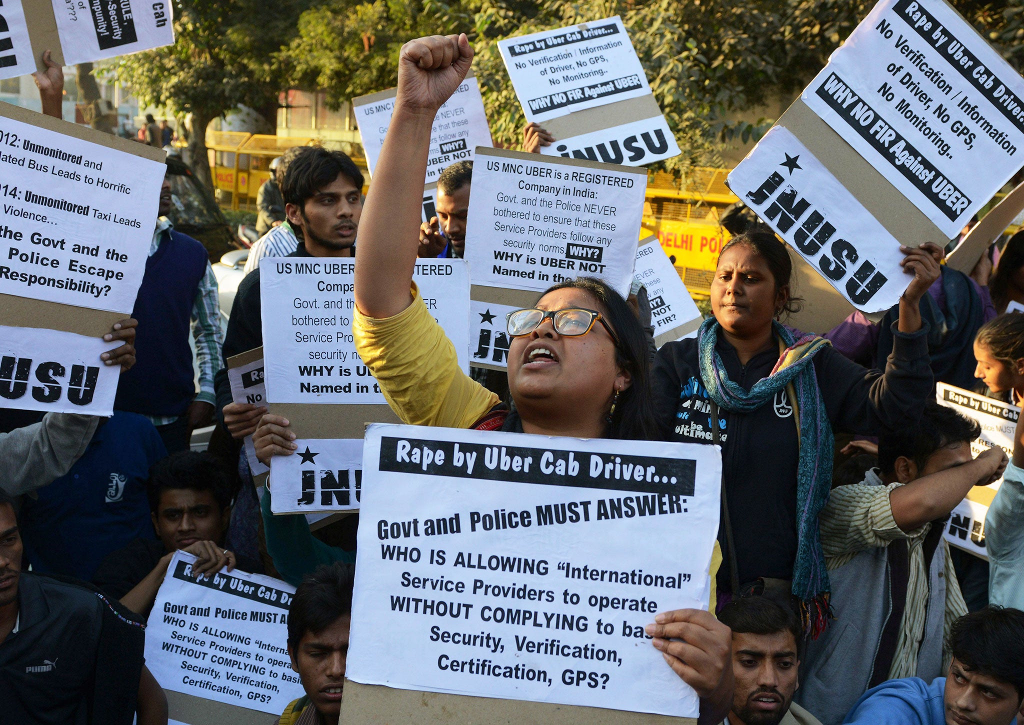 Indian residents hold placards and chant slogans as they take part in a protest against the alleged rape of a passenger by a driver working for the Uber taxi company in New Delhi on December 7, 2014